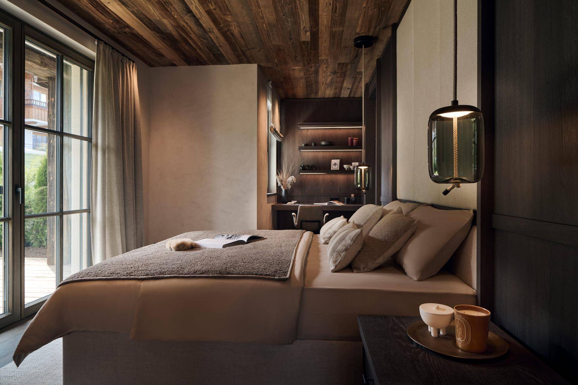 Helles Schlafzimmer mit bequemen Bett, Schreibtisch und Holzbalkendecke, ideal zum Entspannen.