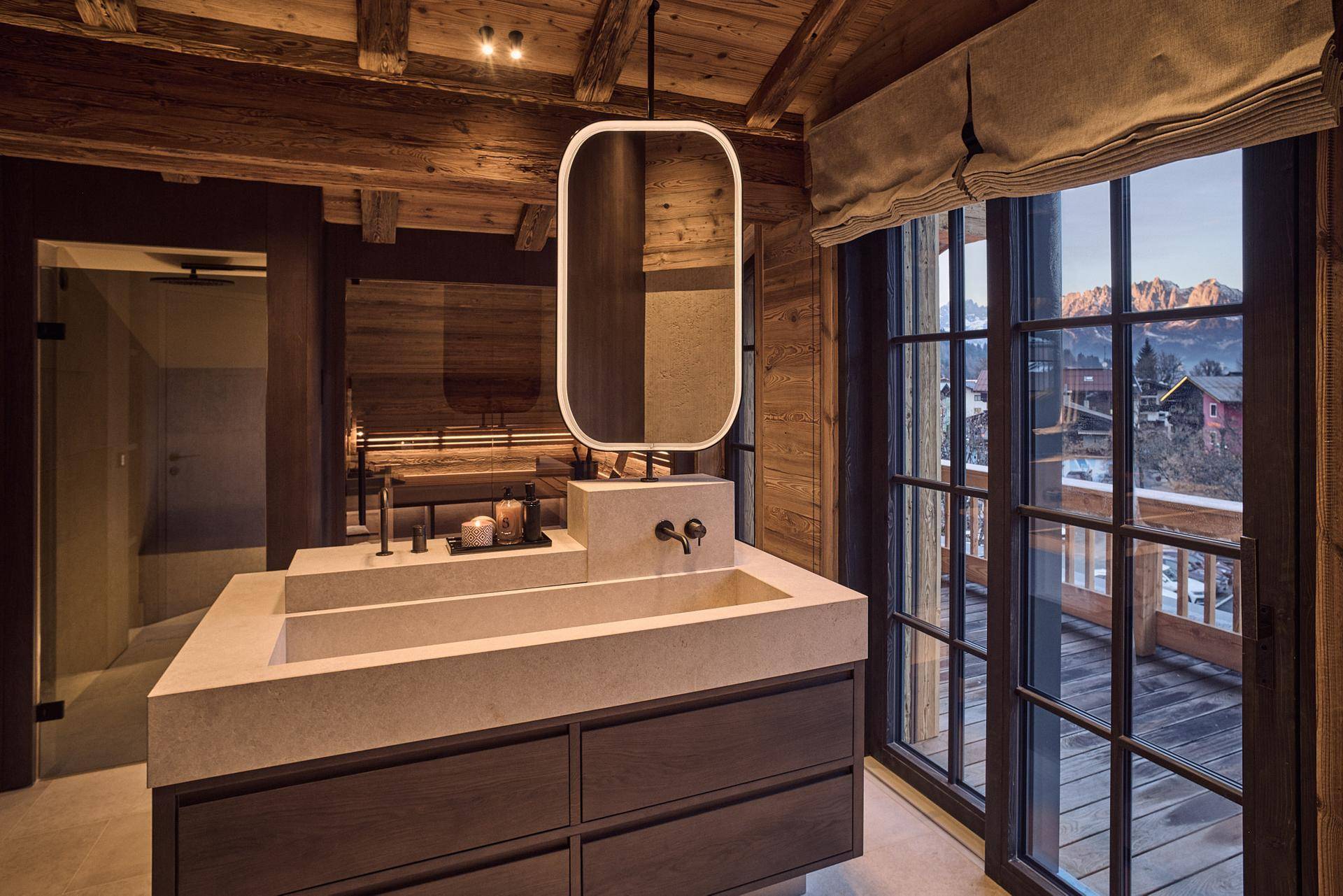 Modernes Badezimmer mit Doppelwaschbecken, großem Spiegel und Zugang zu einem Balkon.