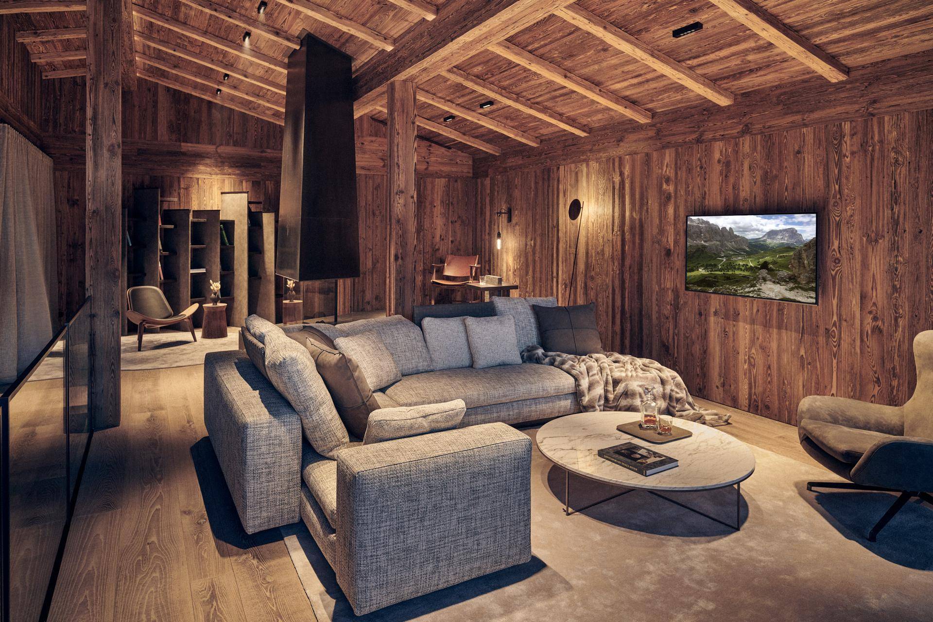 Gemütliches Wohnzimmer im Chalet-Stil mit Holzwänden, Holzbalkendecke und modernem Sofa.