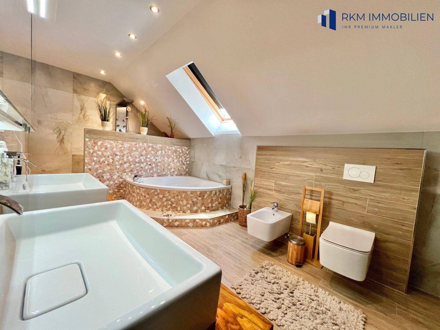 Luxuriöses Badezimmer im Dachgeschoss mit Whirlpool, Doppelwaschbecken und Dachfenster.