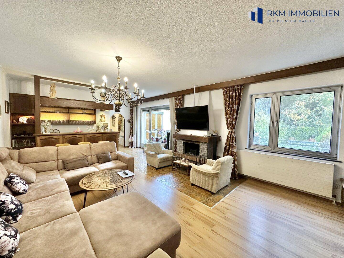 Gemütliches Wohnzimmer mit großem Sofa, Kamin und integrierter Bar, ideal für gesellige Abende.