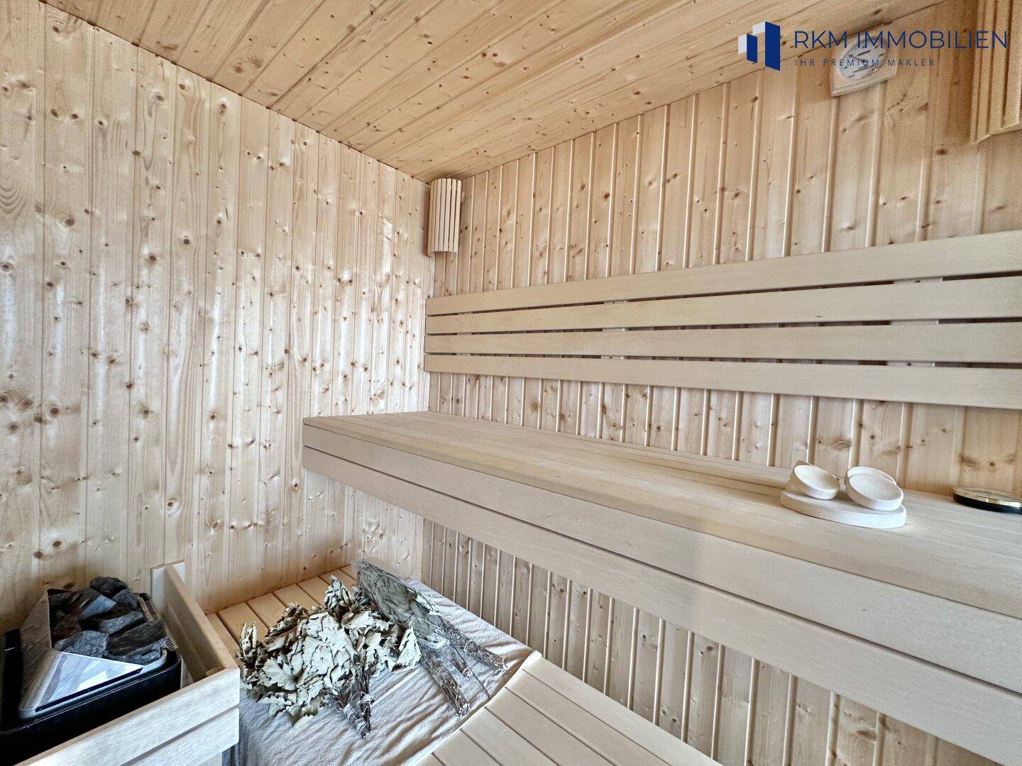 Innenansicht einer traditionellen Holzsauna mit bequemen Bänken und Saunaofen.