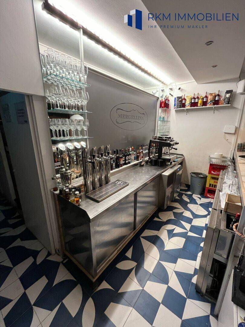 Gut ausgestattete Bar mit Zapfanlage, Gläserregal und Edelstahlflächen, bereit für den Betrieb, mit Kameraüberwachung.