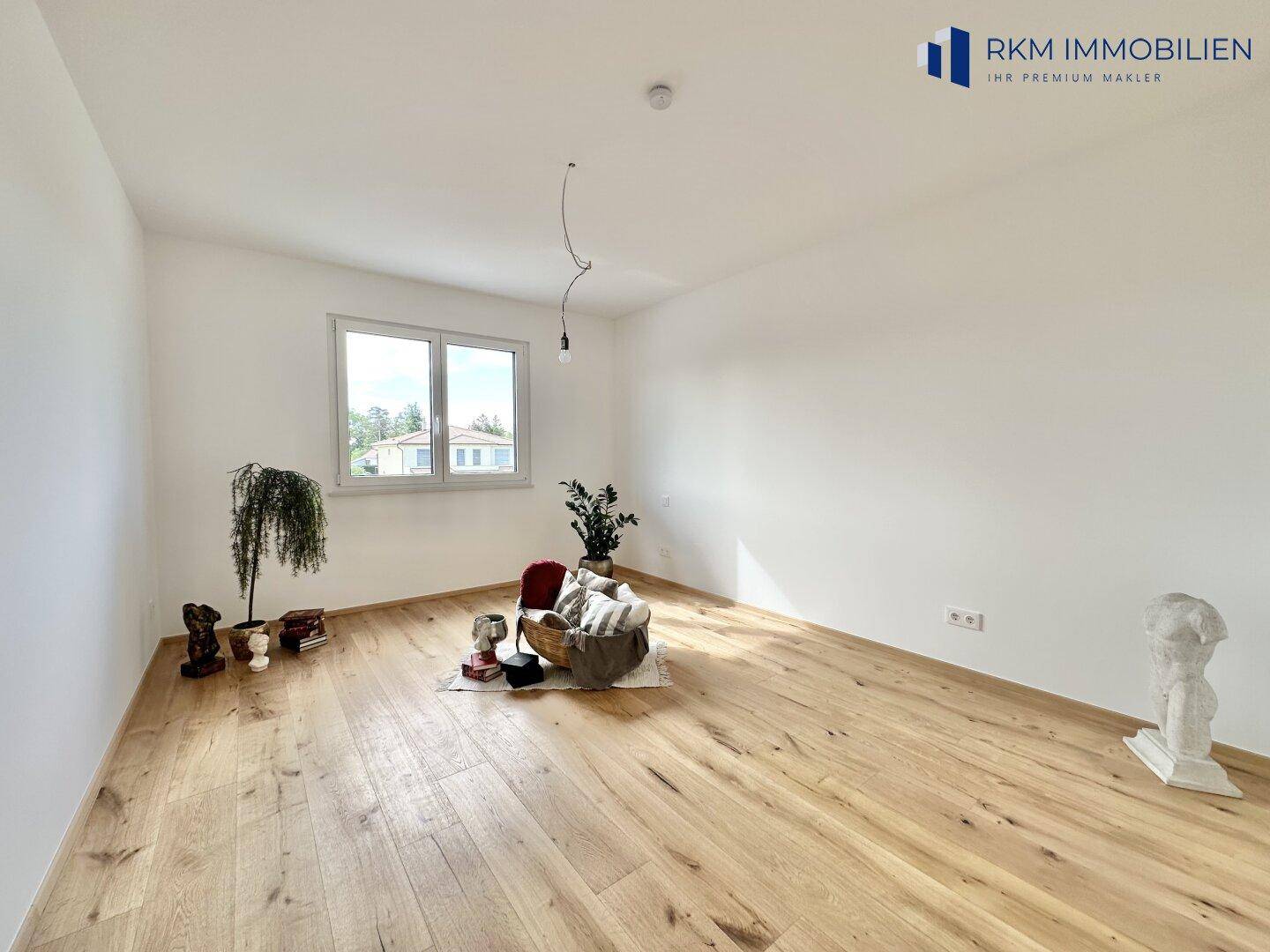 Ruhiges Zimmer mit Eichenparkett und einem Fenster, das einen angenehmen Ausblick bietet.