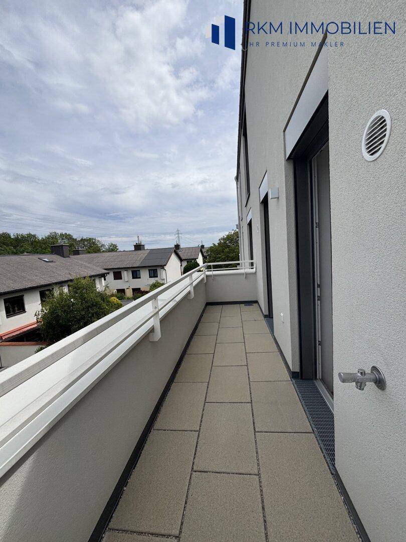Langer Balkon mit Fliesenboden und Blick auf die umliegende Wohngegend, ideal zum Entspannen.