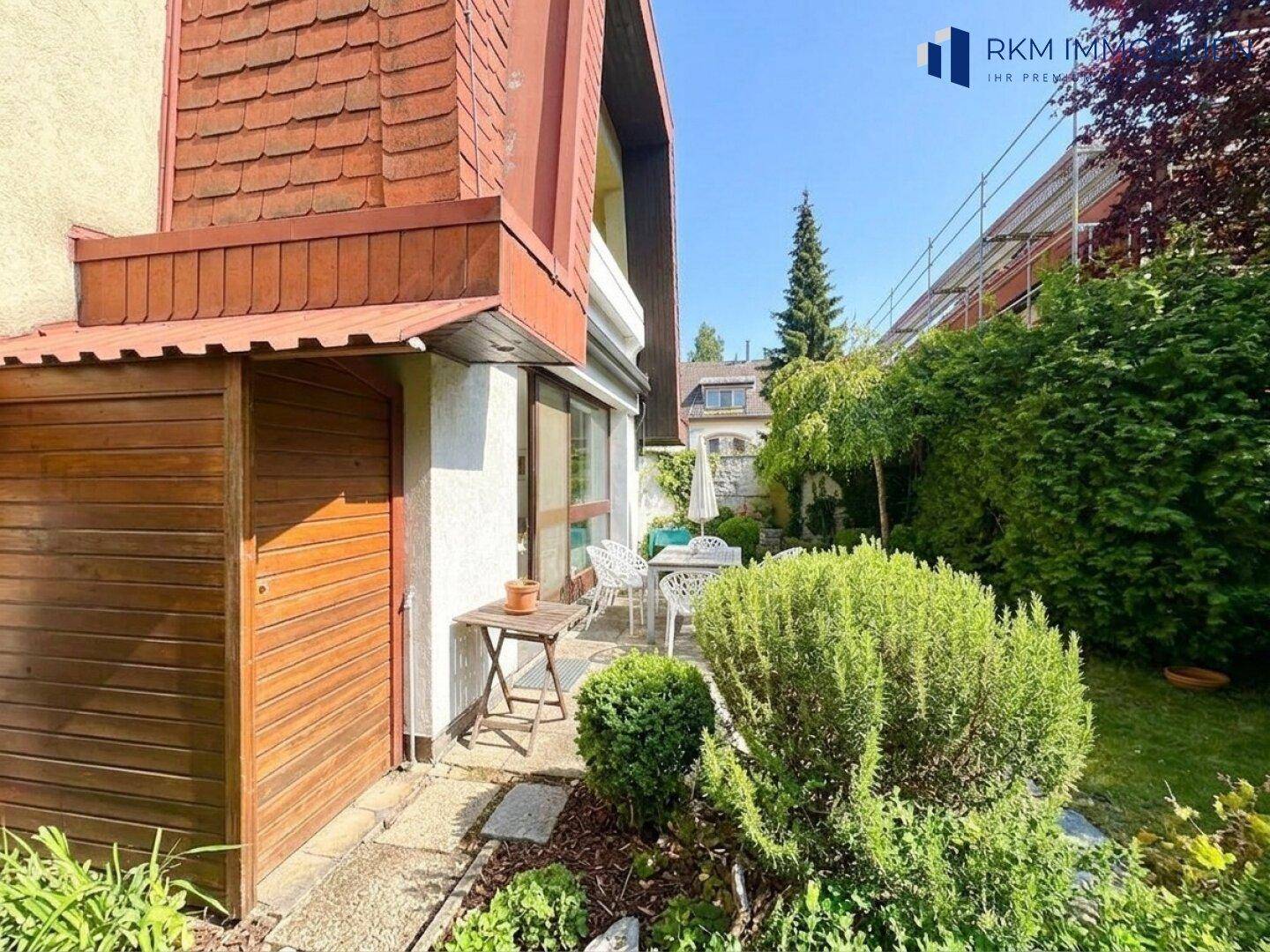 Außenansicht des Hauses mit Garten, Terrasse und einem praktischen Holzschuppen.