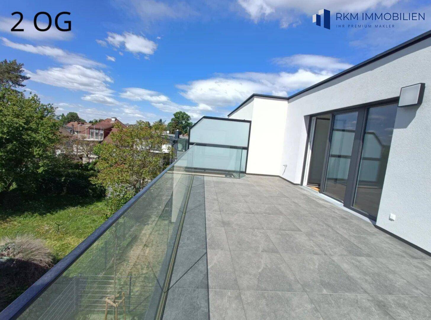 Großzügige Dachterrasse im zweiten Obergeschoss mit Glasgeländer und weitem Ausblick.