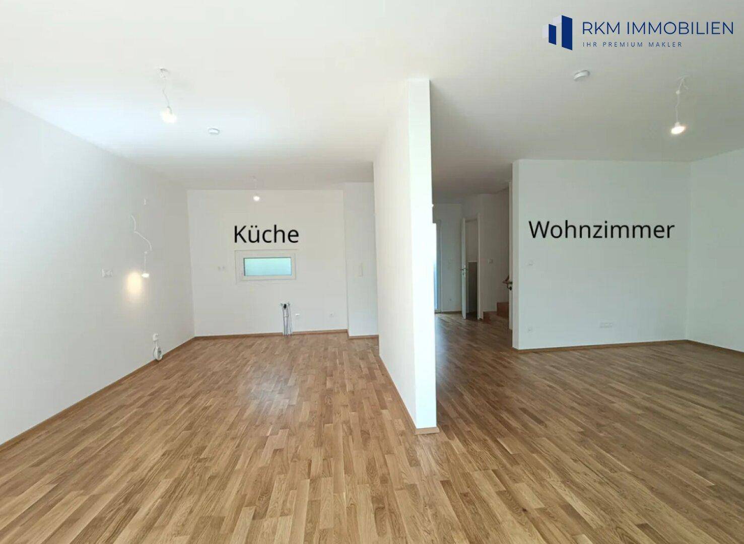 Offener Wohn- und Küchenbereich im Erdgeschoss mit Eichenparkett und viel Tageslicht.