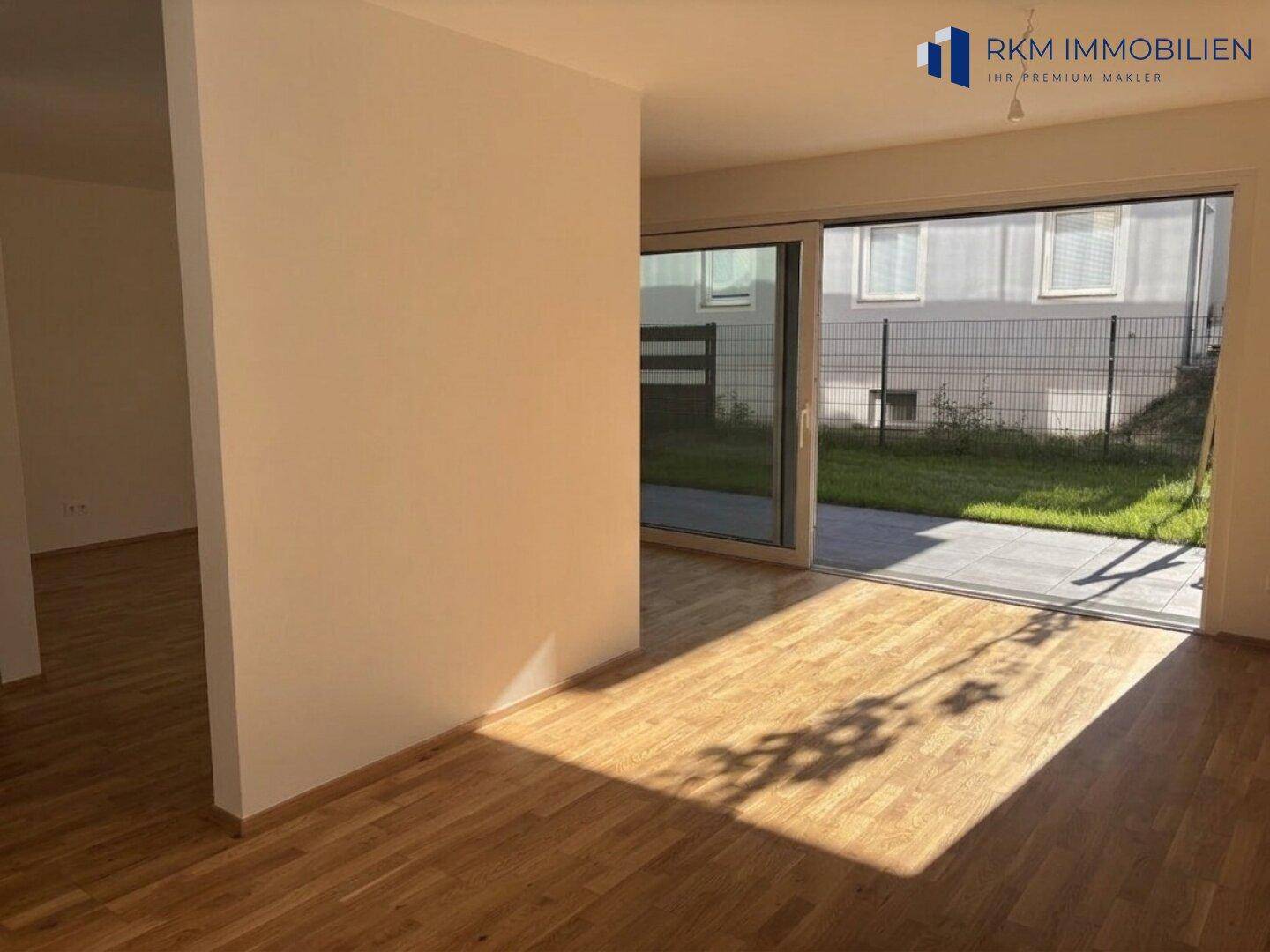 Lichtdurchfluteter Wohnbereich mit direktem Zugang zur Terrasse und Blick in den Garten.
