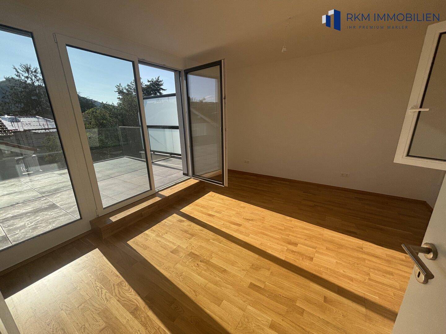 Helles Schlafzimmer mit direktem Zugang zur großzügigen Dachterrasse und Eichenparkett.
