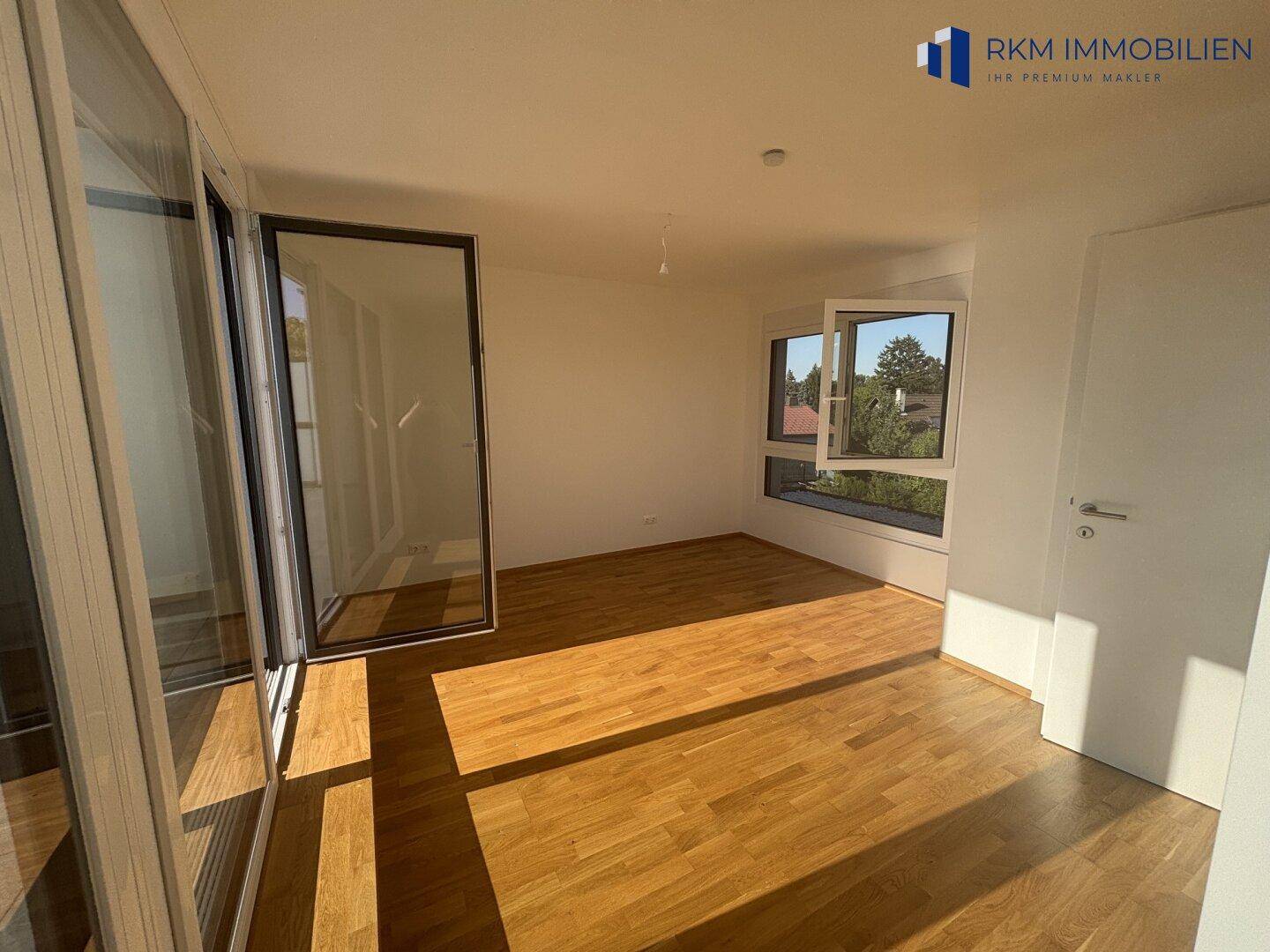 Geräumiges Schlafzimmer mit viel Tageslicht und Zugang zur sonnigen Dachterrasse.