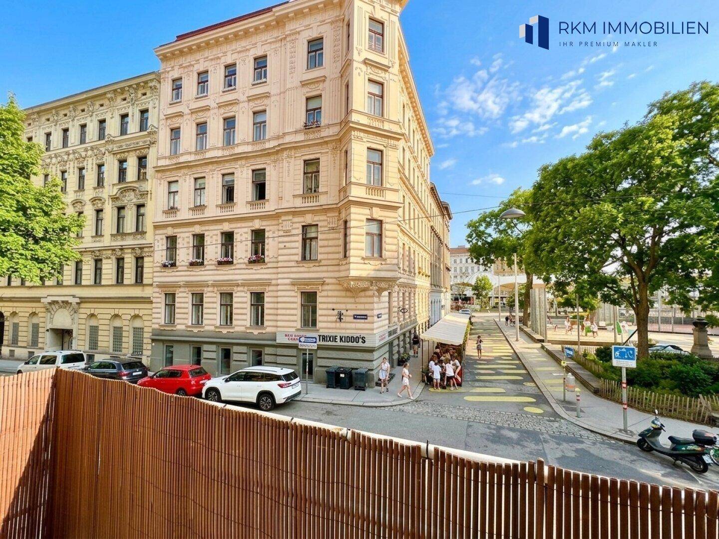 Historisches Eckgebäude mit klassischer Architektur und Blick auf die belebte Straße.