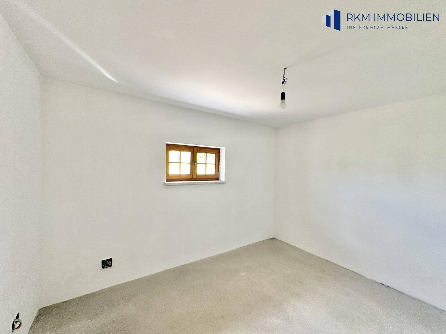 Kleiner, heller Raum mit einem Fenster, bereit für den weiteren Ausbau und die individuelle Nutzung.