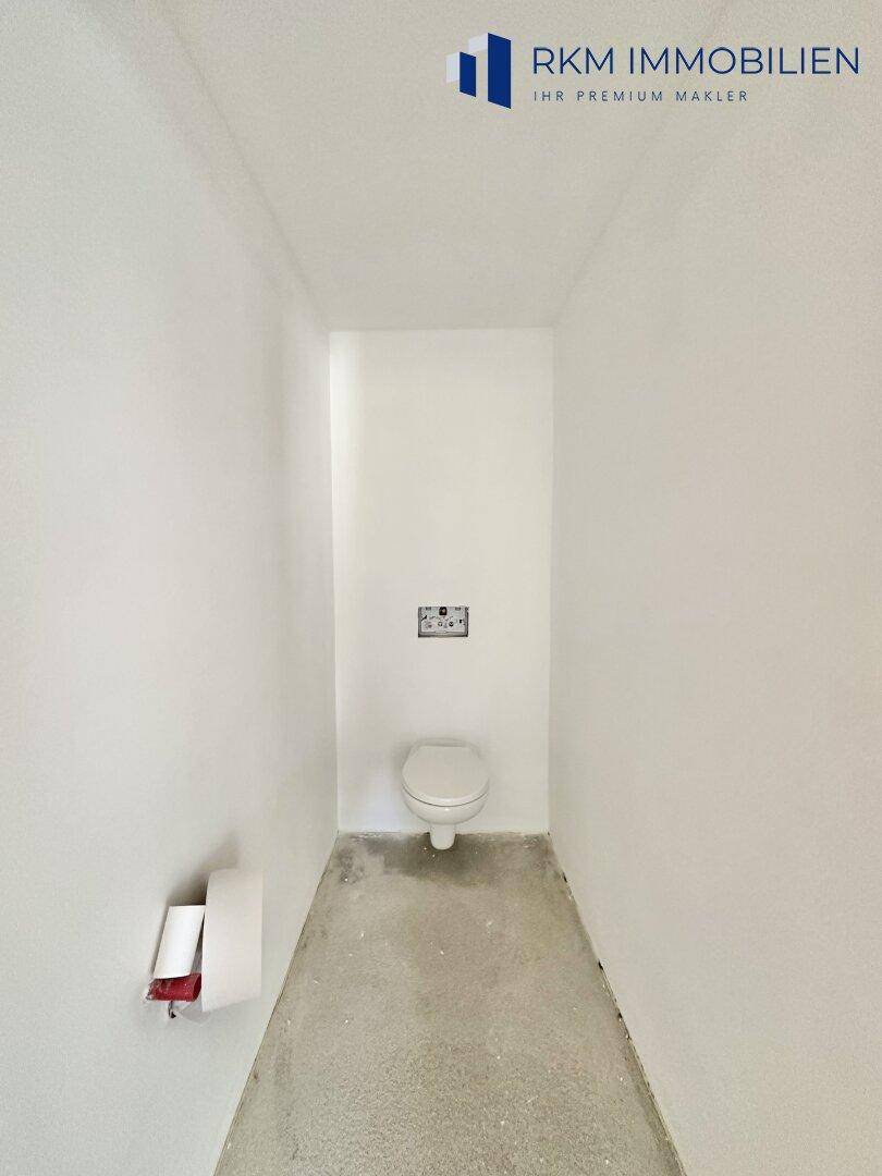 Unfertige Gästetoilette mit Wand-WC, bereit für die Endmontage und Fliesenarbeiten.