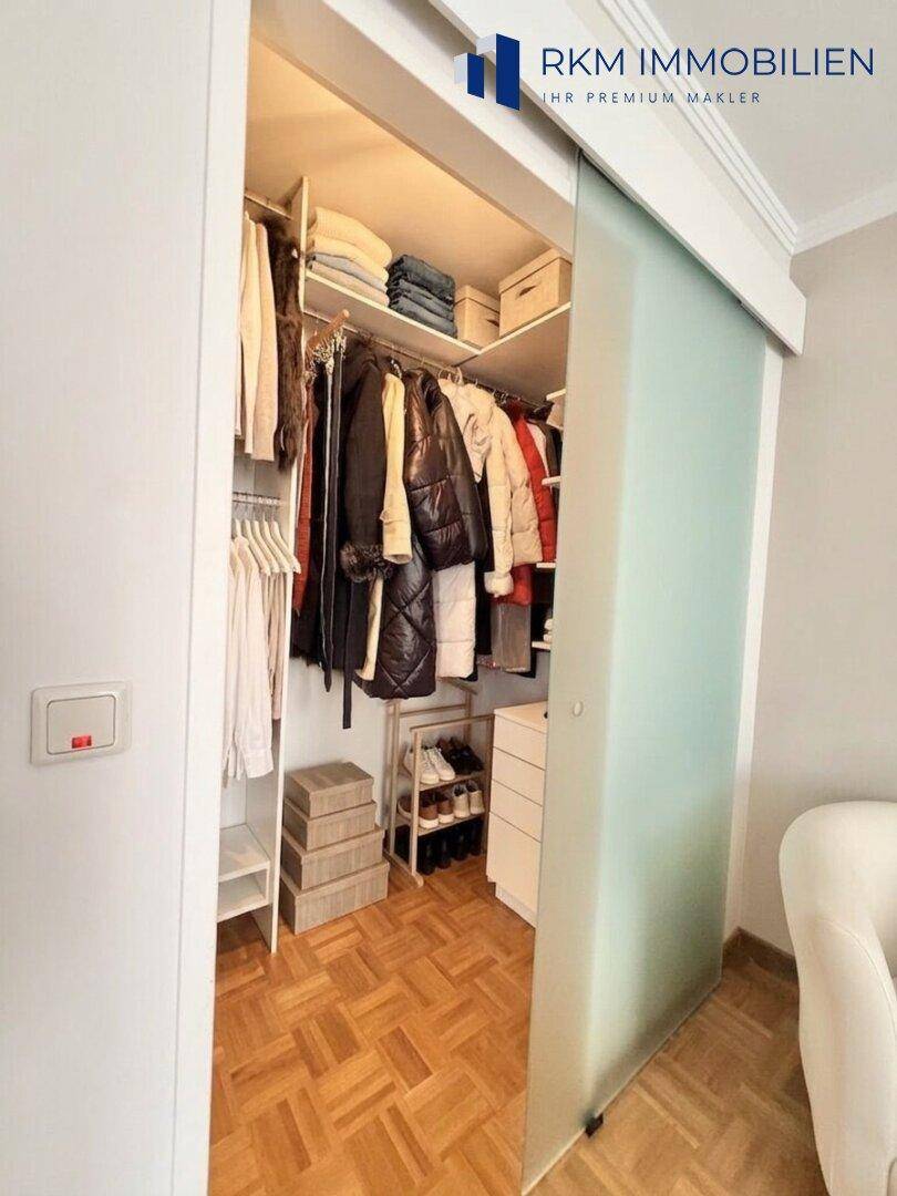 Praktischer begehbarer Kleiderschrank mit viel Stauraum und Schiebetür.