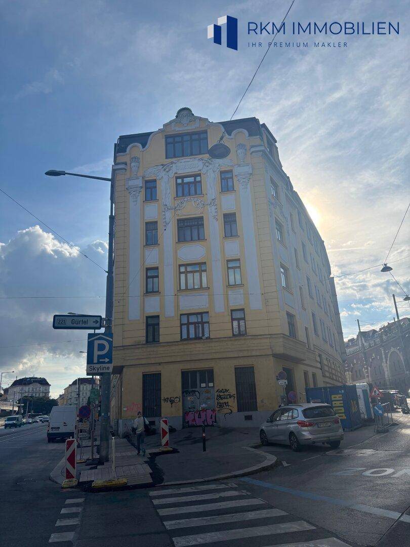 Historisches Eckgebäude in der Stadt mit klassischer Architektur, vielen Fenstern und Blick auf die Straße.