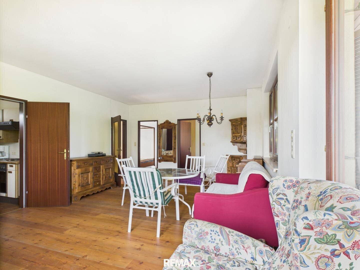 Großer Wohn-Essbereich mit Holzdielenboden, gemütlichen Sofas und Blick in angrenzende Räume.