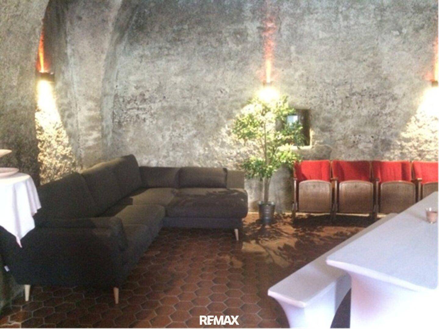 Gemütlicher Lounge-Bereich in einem historischen Gewölbekeller mit bequemen Sitzgelegenheiten und warmem Licht.