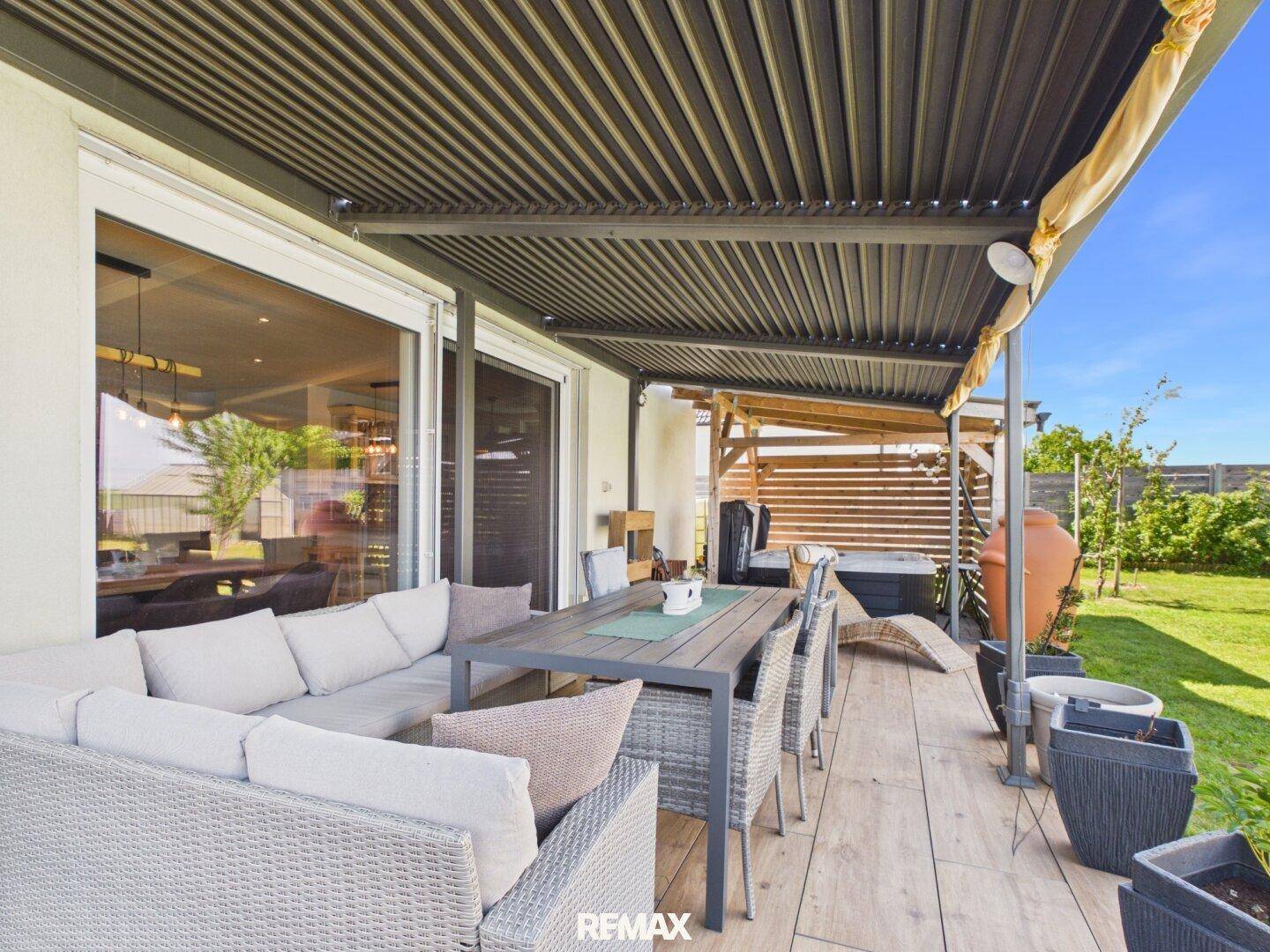 Gemütliche Terrasse mit bequemen Lounge-Möbeln und Esstisch, ideal für entspannte Stunden im Freien.