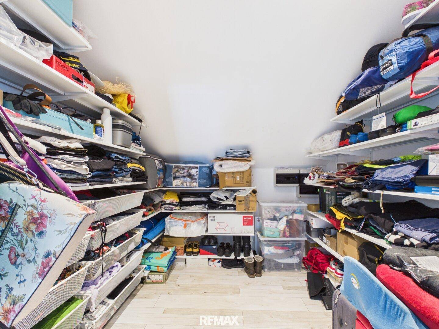 Geräumiger begehbarer Kleiderschrank im Dachgeschoss mit vielen Regalen und Stauraum.