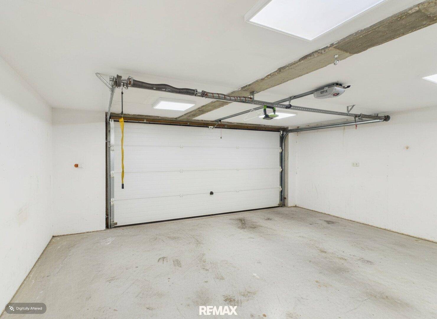 Geräumige, leere Garage mit automatischem Toröffner und Betonboden.