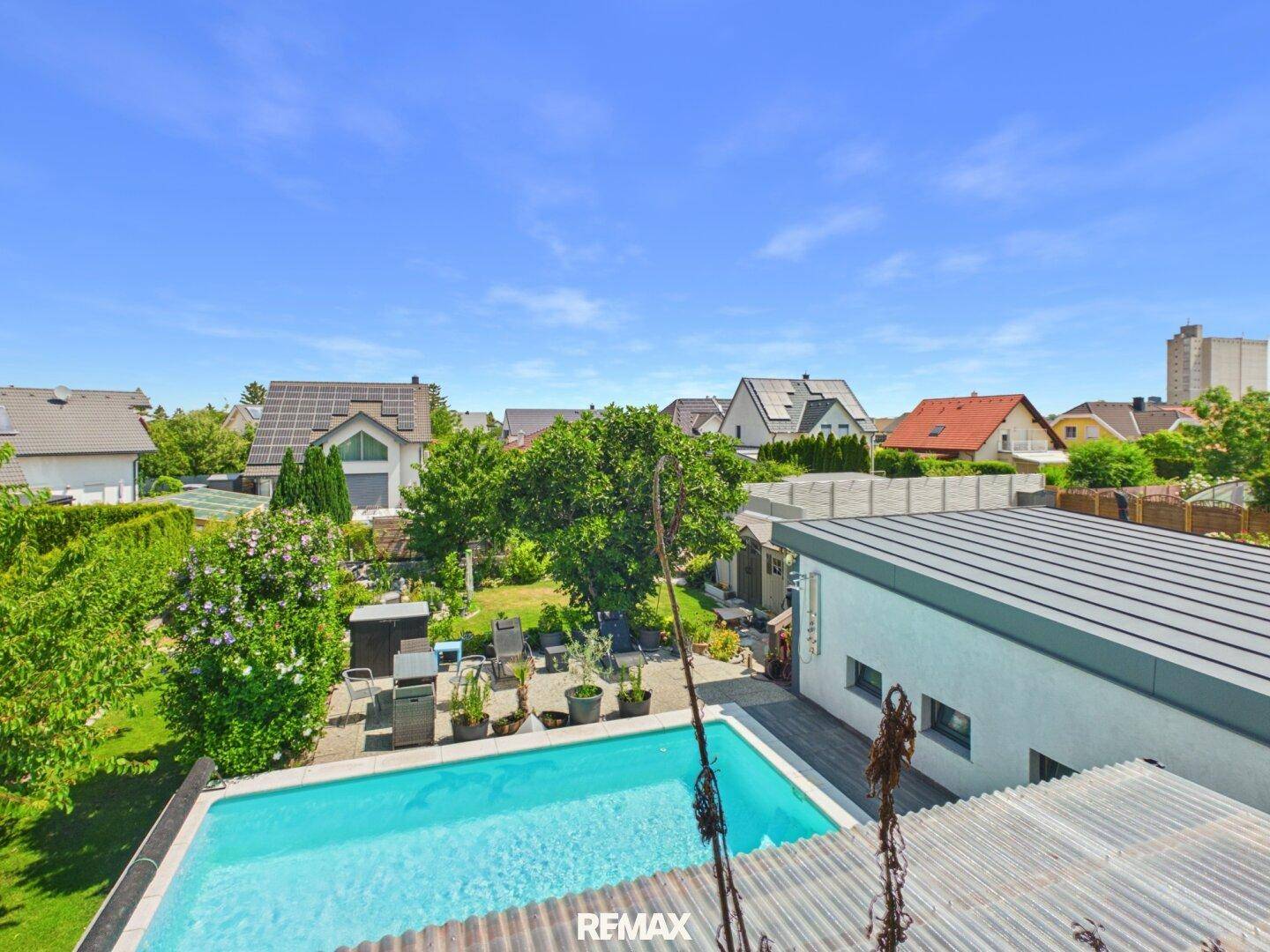 Überblick über das Anwesen mit Pool, Garten und umliegender Bebauung.