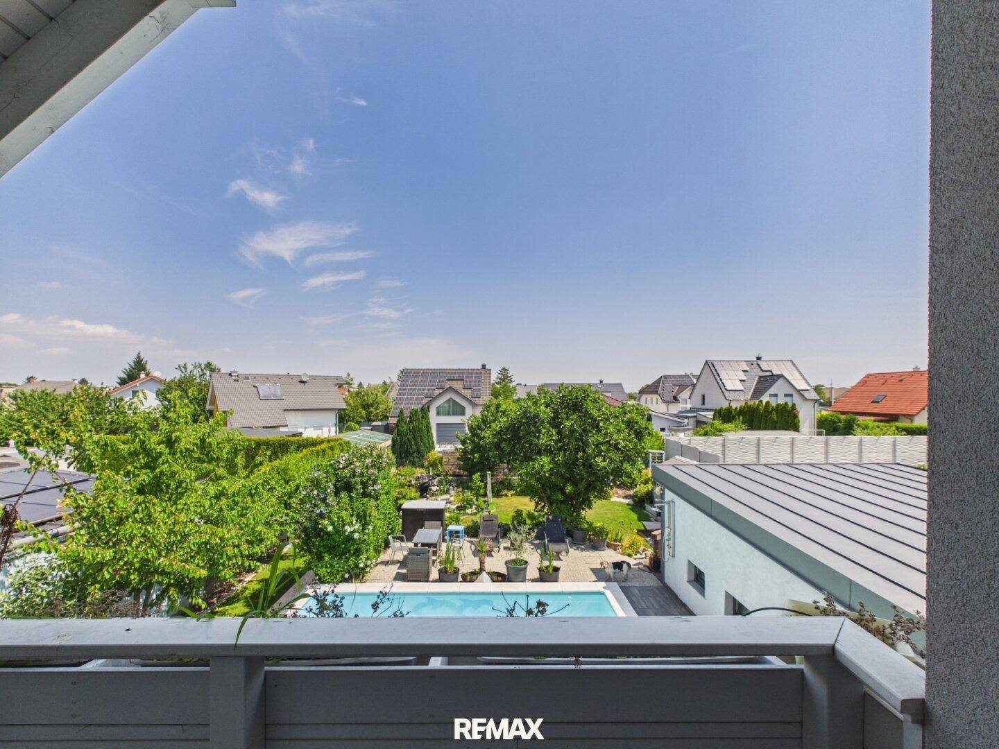 Ausblick vom Balkon auf den Garten, Pool und die Nachbarschaft.