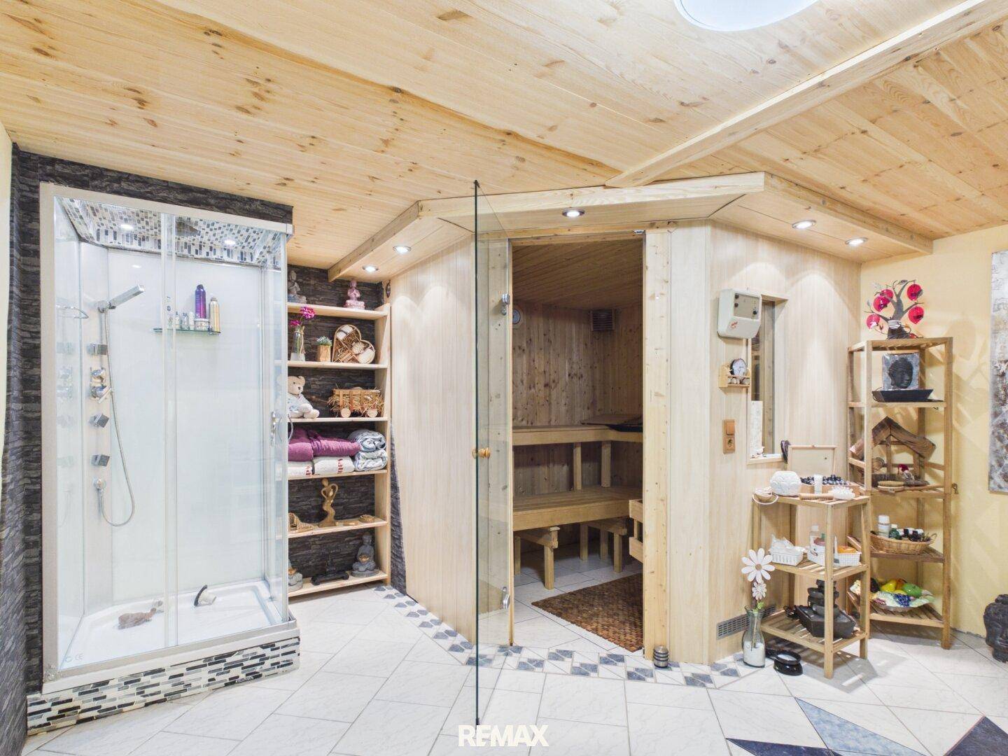 Wellnessbereich mit holzvertäfelter Sauna und moderner Duschkabine.