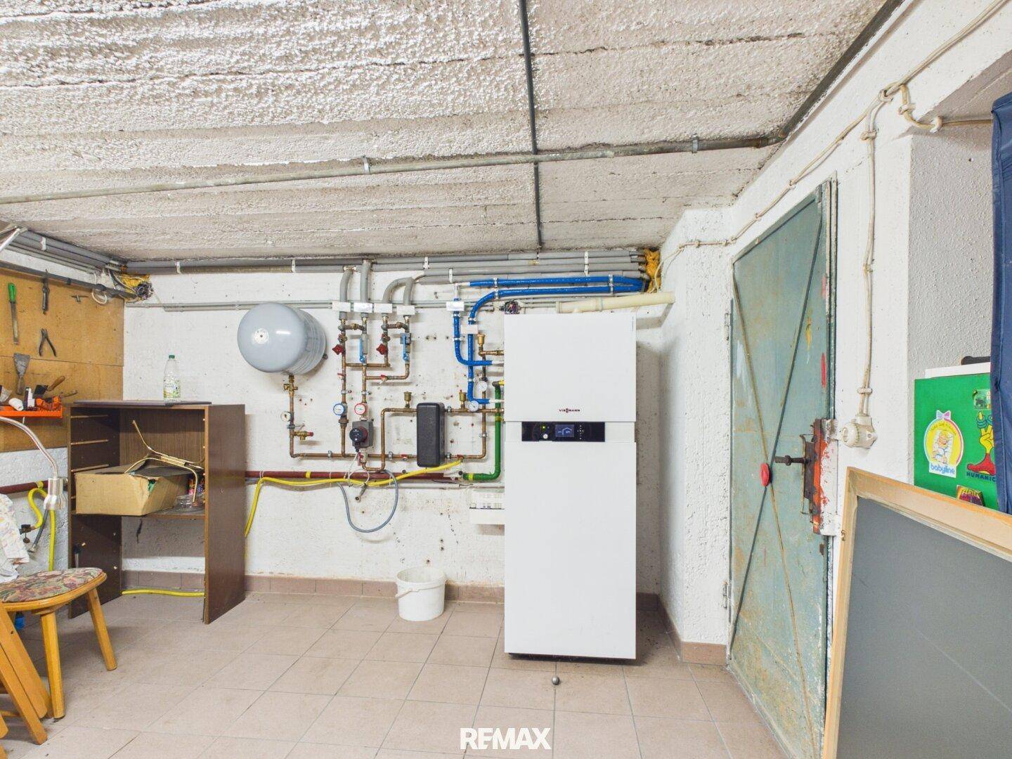 Kellerraum mit moderner Heizungsanlage und sichtbaren Installationen, ideal als Technik- oder Abstellraum.