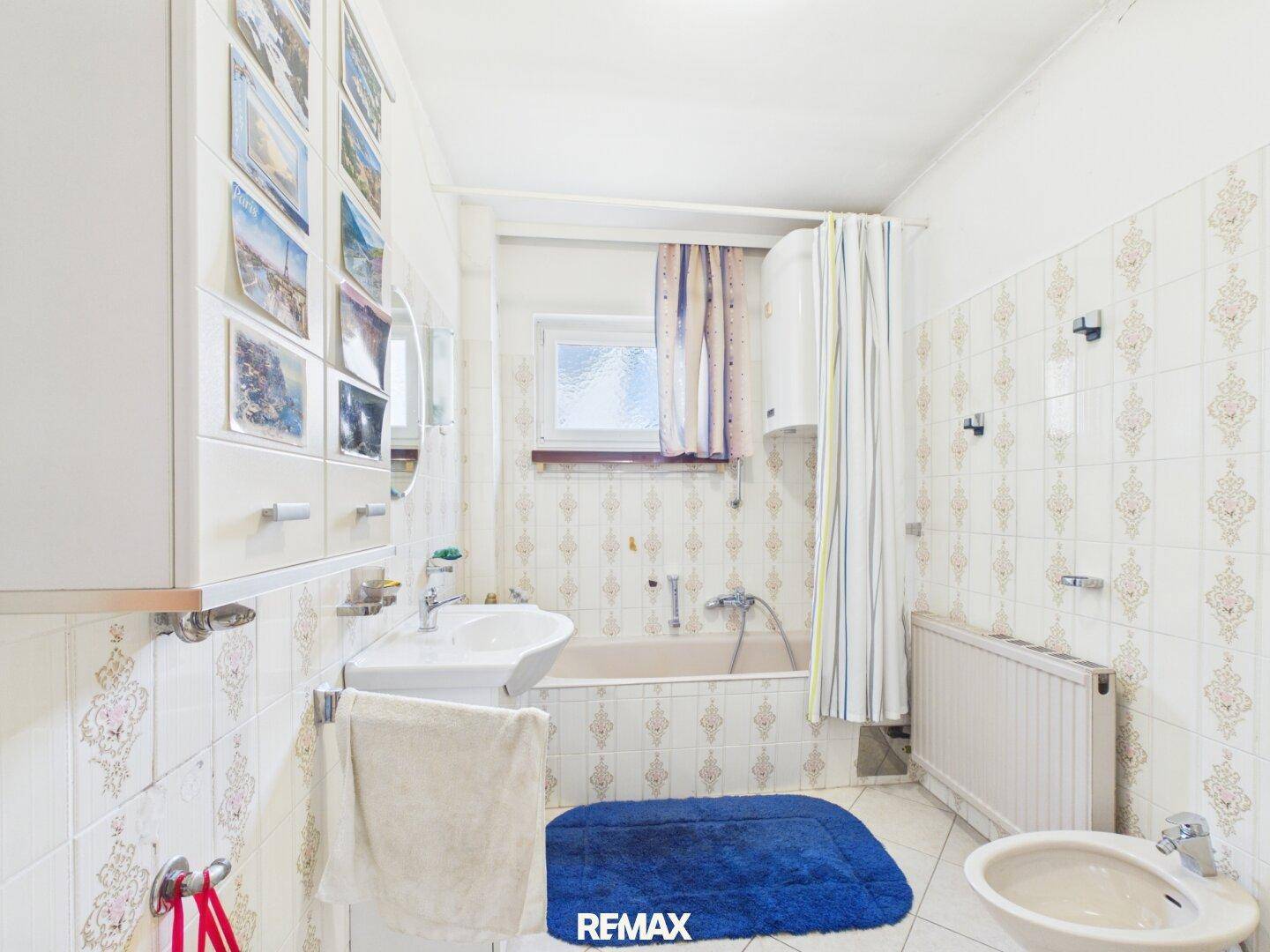 Badezimmer mit Badewanne, Waschbecken, Bidet und gemusterten Fliesen.