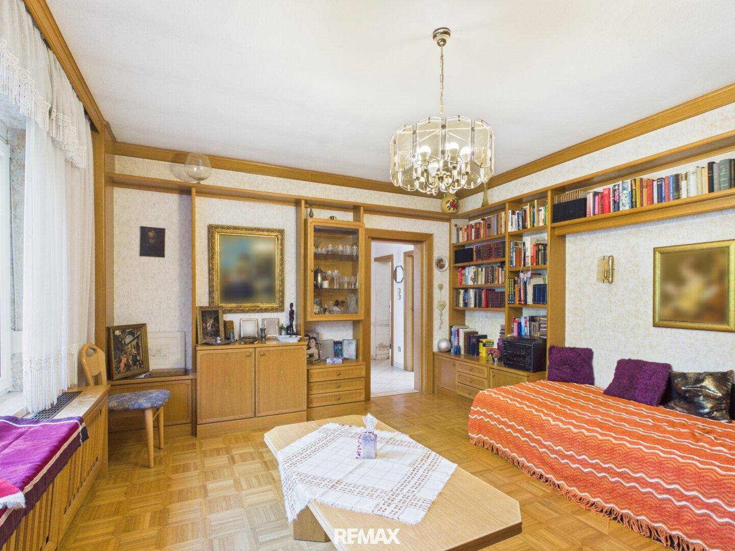 Gemütliches Wohnzimmer mit Parkettboden, Holzregalen und traditioneller Einrichtung.