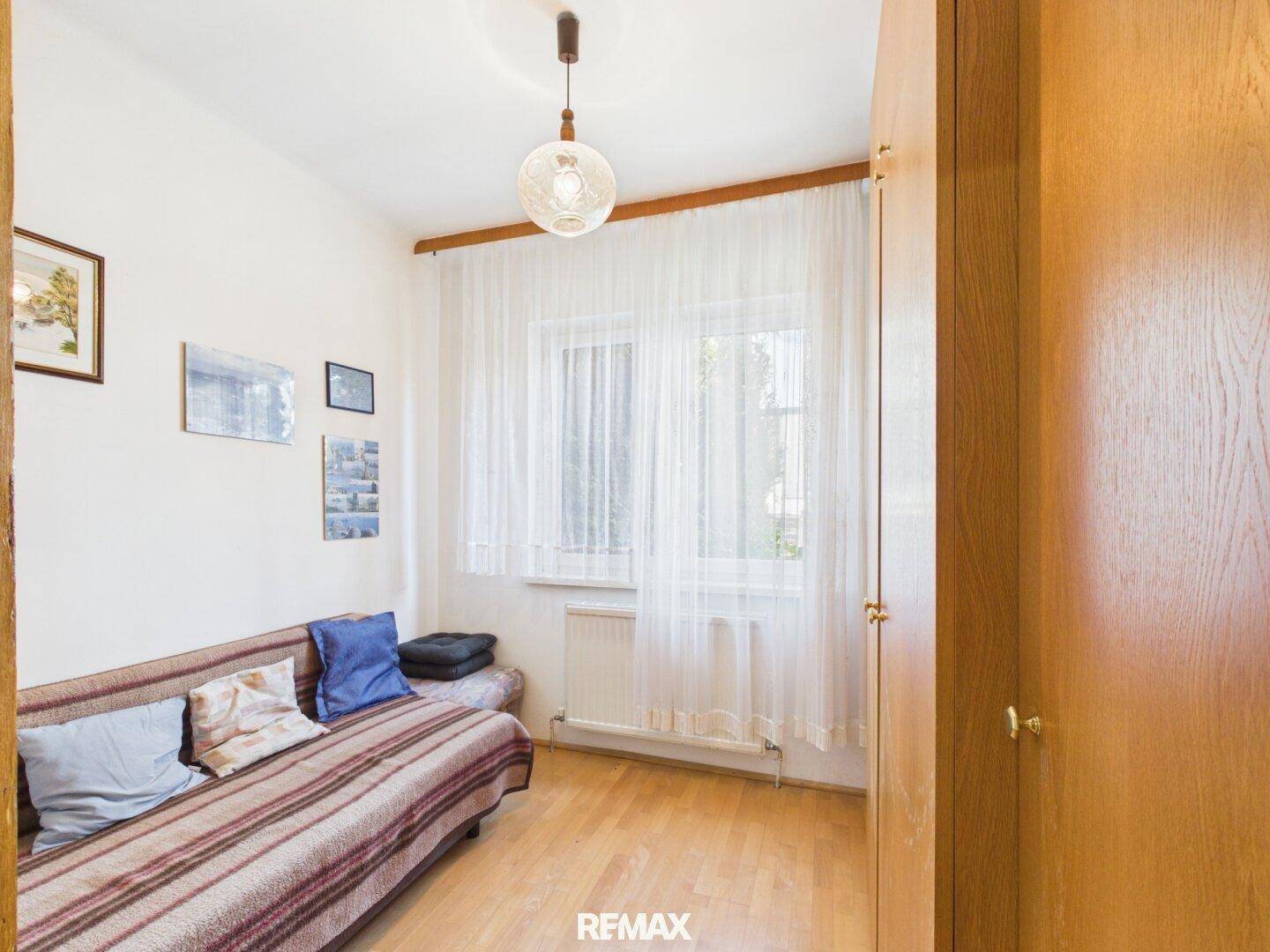 Zweites Schlafzimmer oder Gästezimmer mit Einzelbett und Holzschrank.