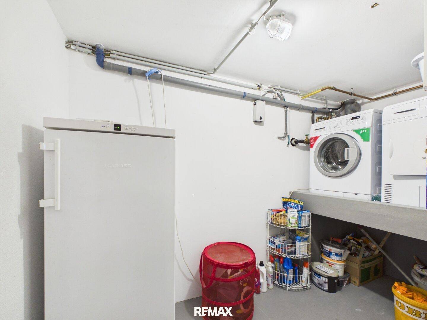 Hauswirtschaftsraum im Keller mit Waschmaschine, Trockner und Gefrierschrank, praktisch und geräumig.