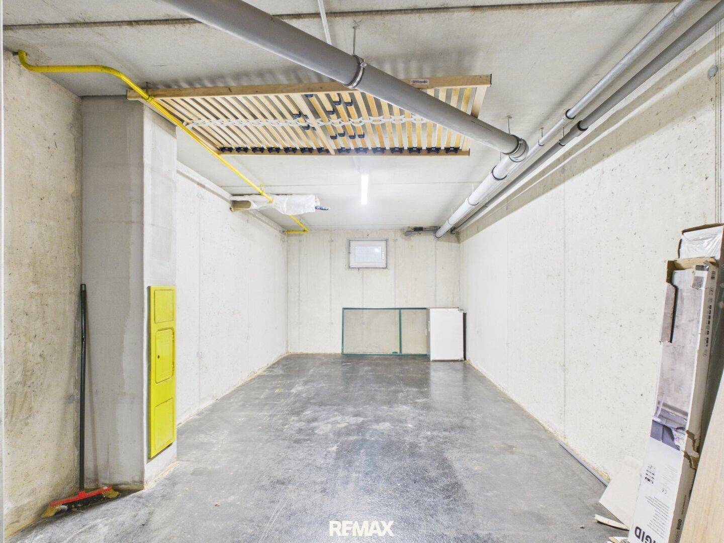 Geräumiger Kellerraum mit Betonboden und sichtbaren Installationen, ideal als Abstellfläche.