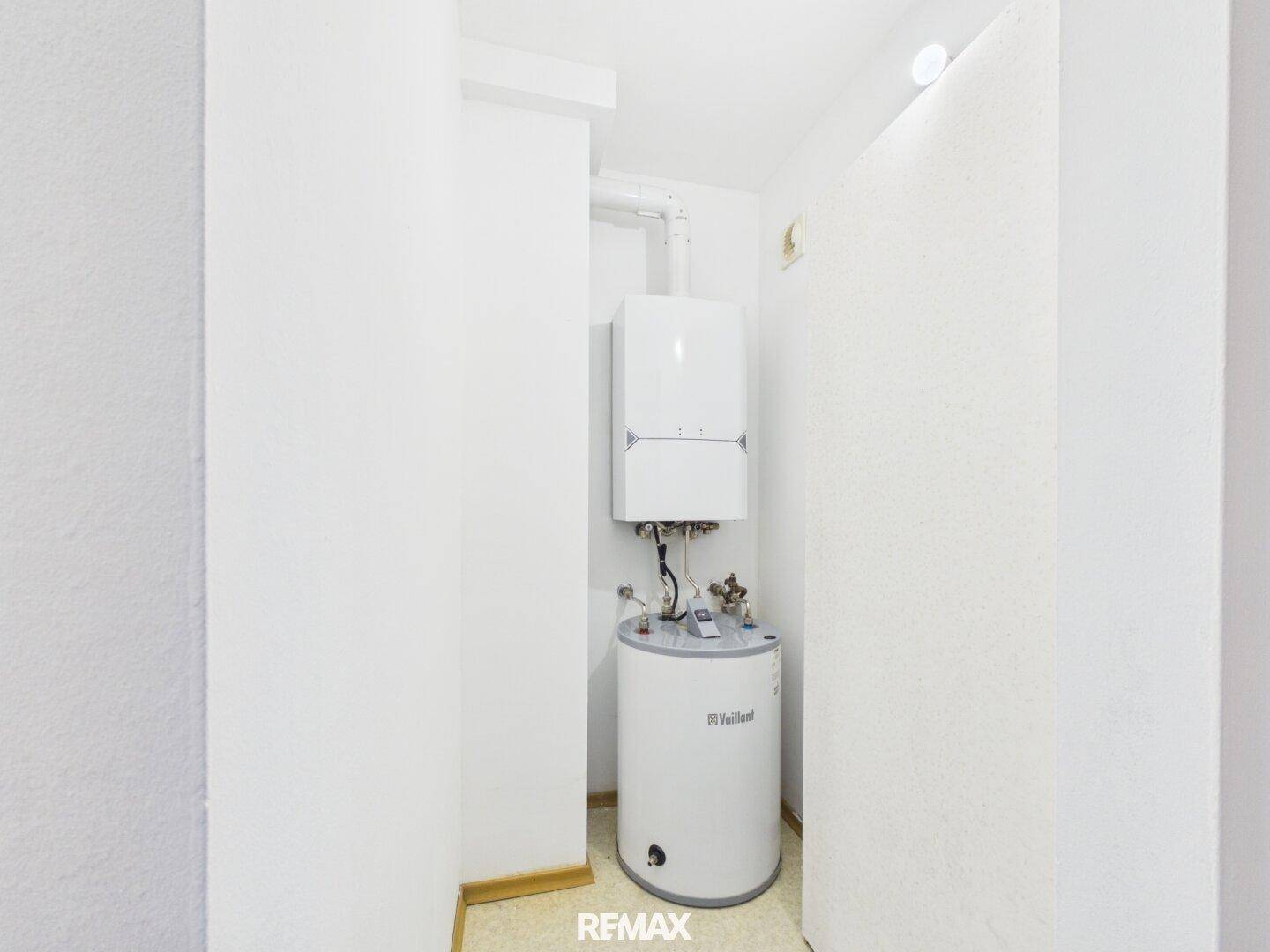 Kleiner Technikraum mit Warmwasserbereiter und Heizungsanlage, effizient und funktional.