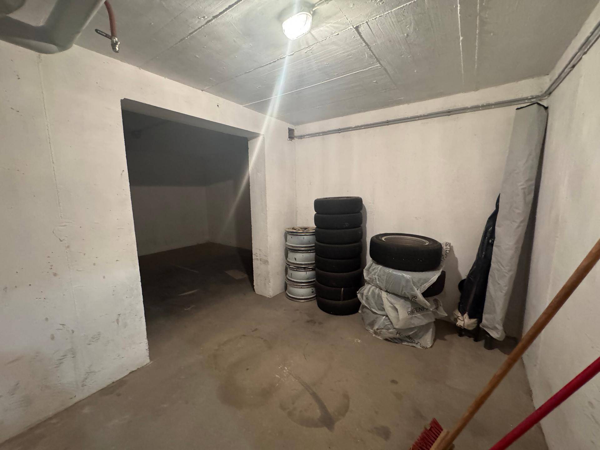 Kellerraum mit Betonboden und gelagerten Autoreifen, bietet vielseitige Nutzungsmöglichkeiten.