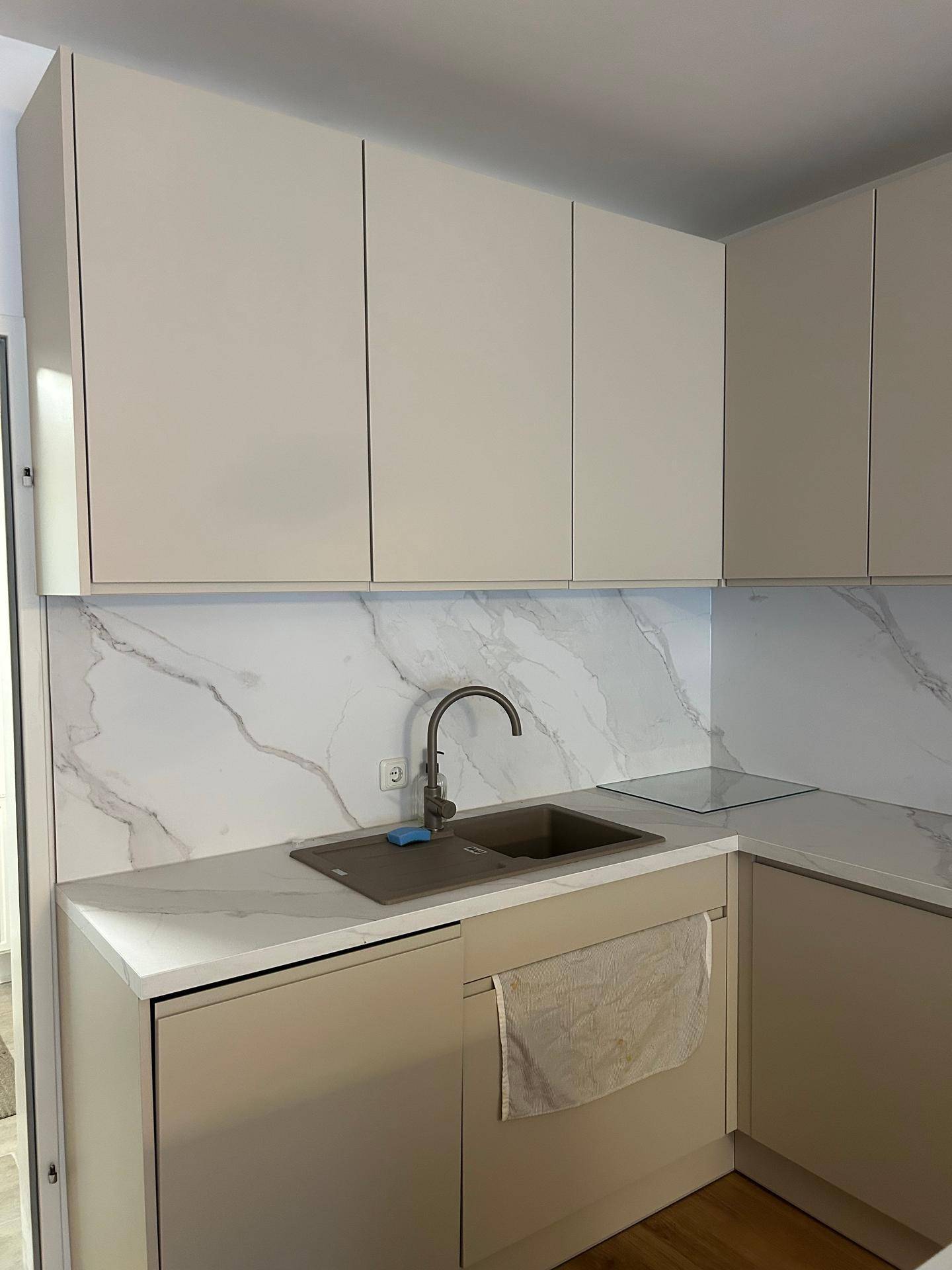 Helle Küche mit Doppelwaschbecken, modernen Schränken und Marmor-Look-Arbeitsplatten.