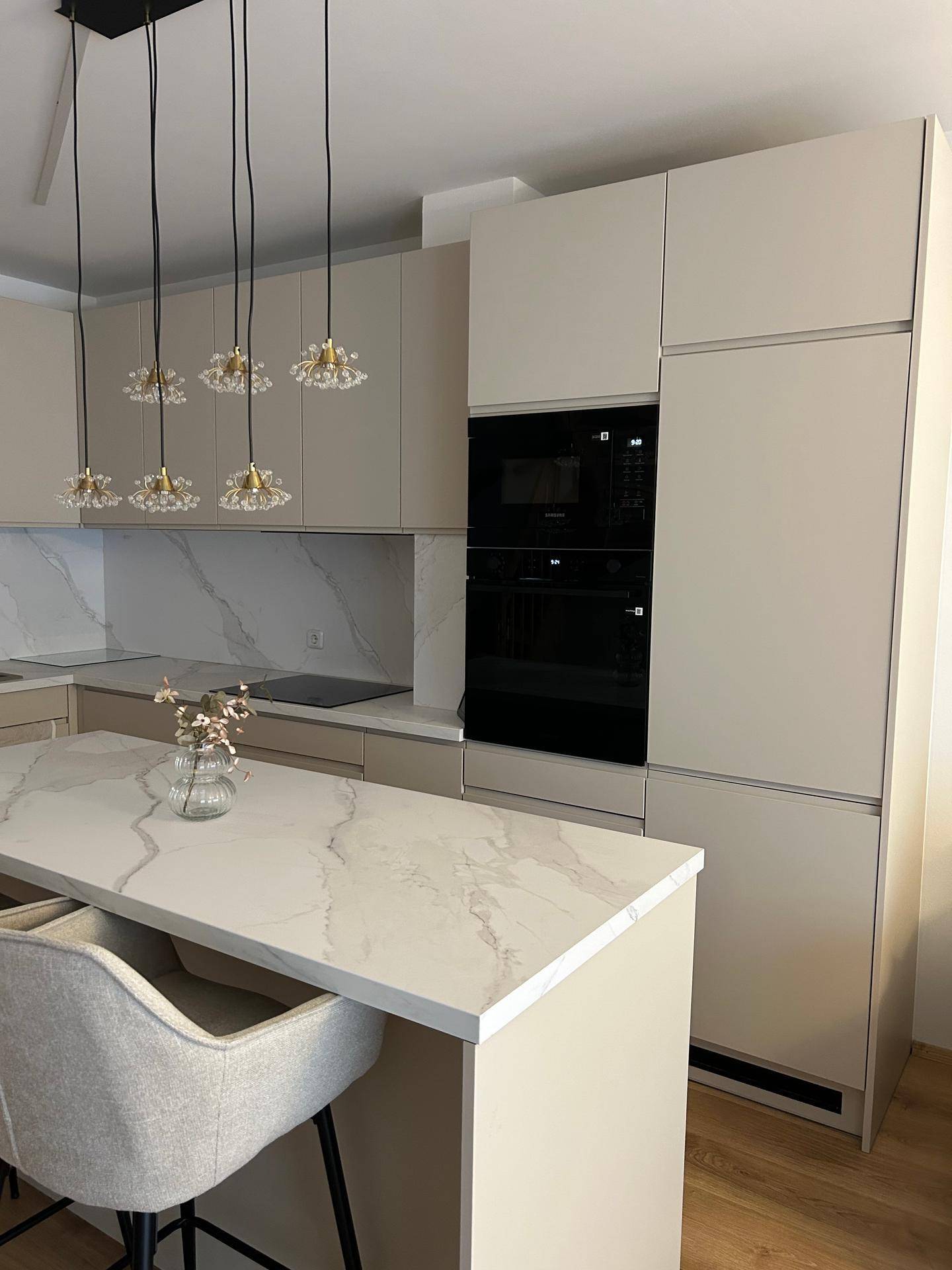 Moderne Einbauküche mit integrierten Geräten und eleganten Marmor-Look-Arbeitsplatten.
