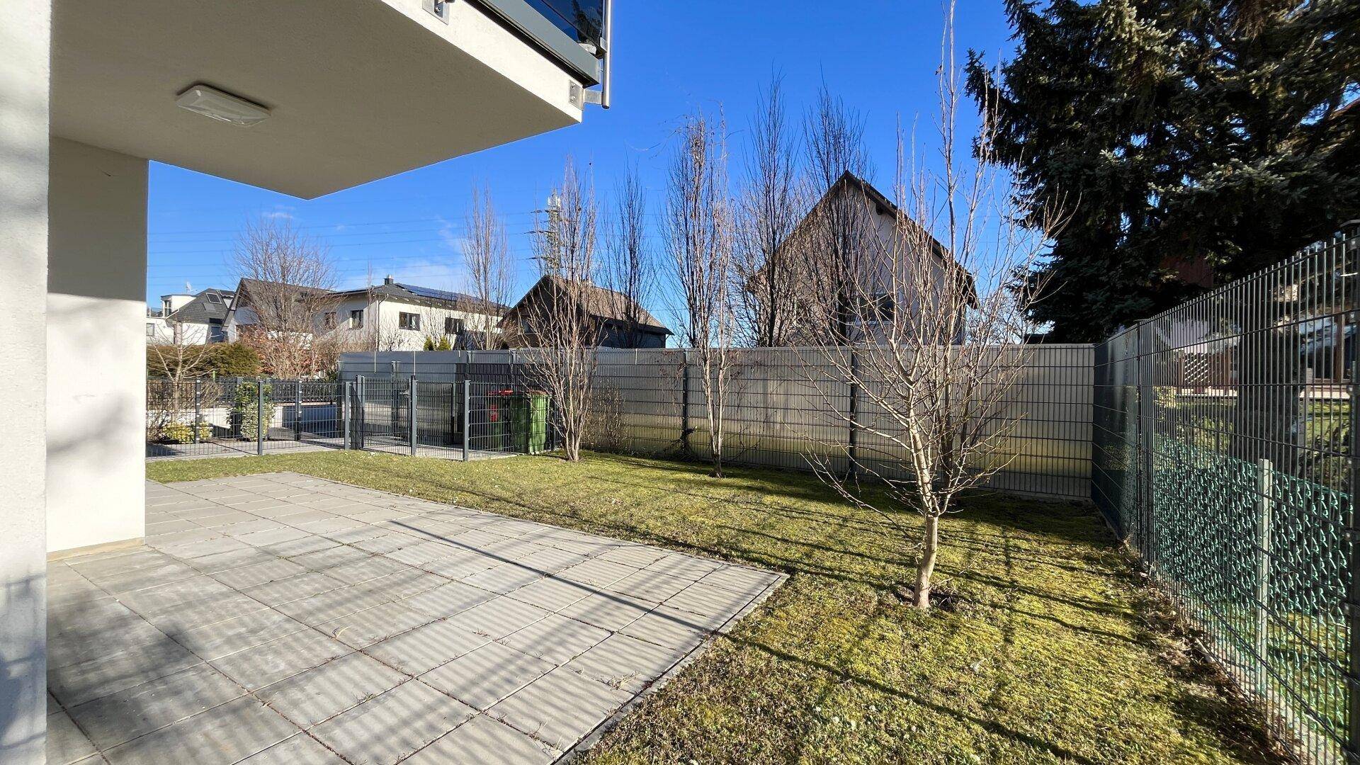 Gepflegte Terrasse mit angrenzendem Garten und Blick auf die Umgebung.