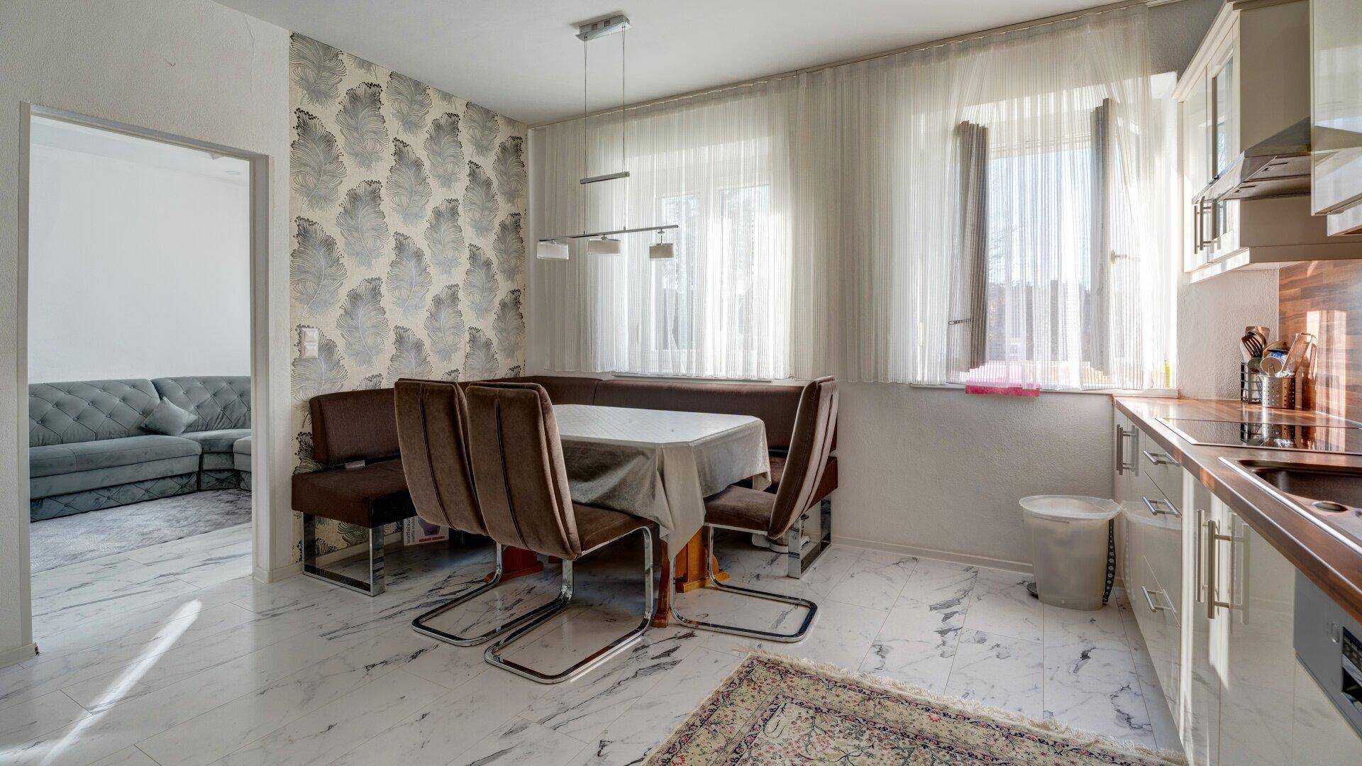 Wohnküche mit Essbereich und Blick in das angrenzende Wohnzimmer, hell und funktional.