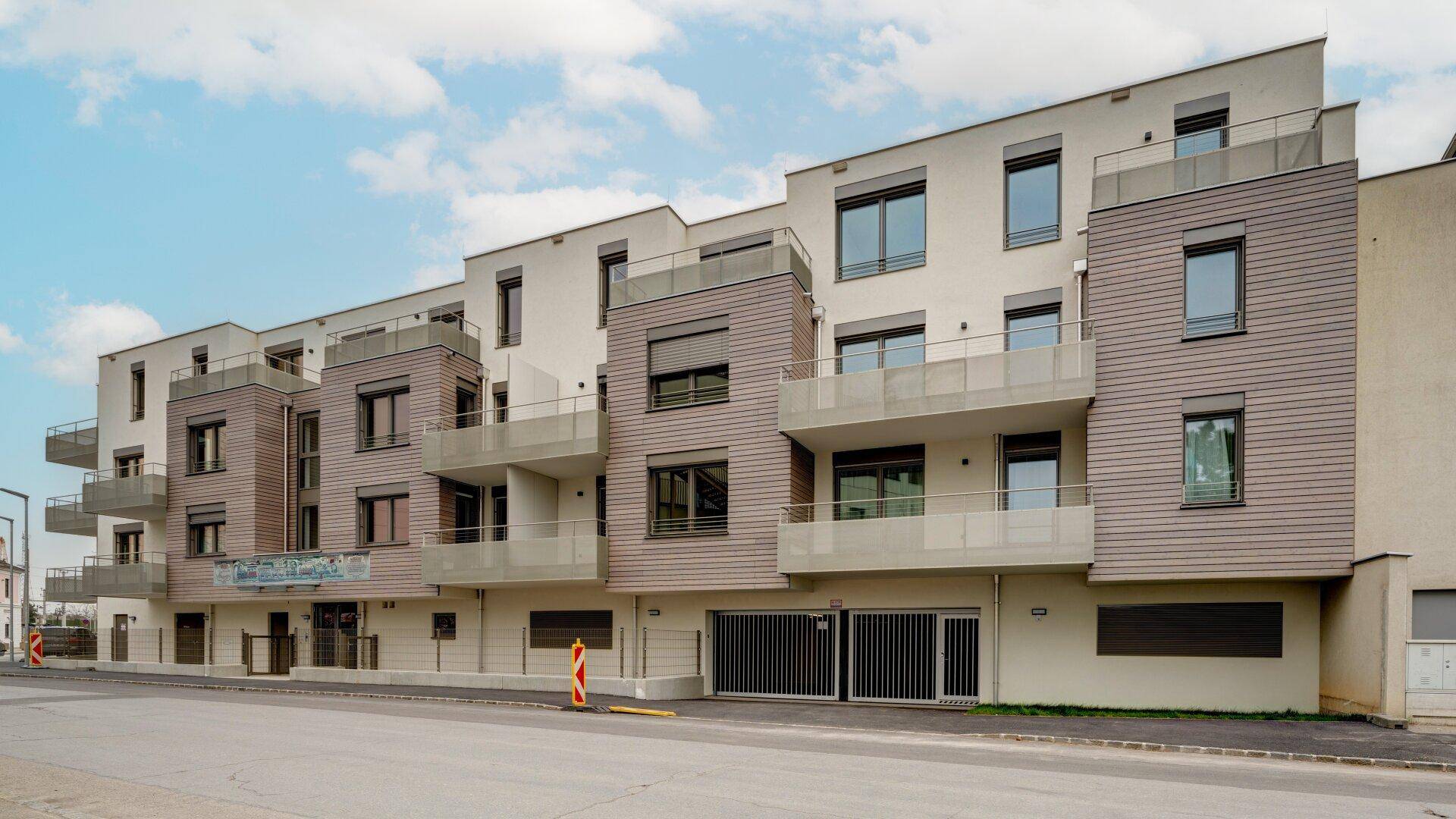 Moderne Wohnanlage mit Balkonen und großen Fenstern an der Fassade.