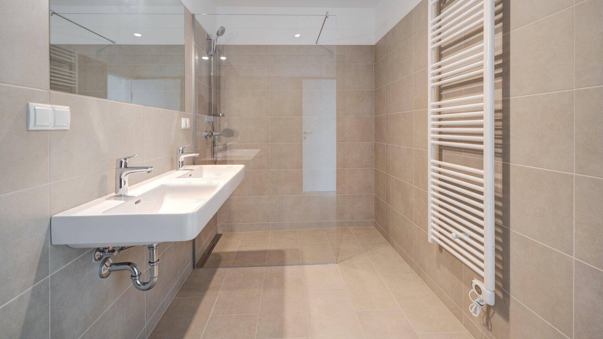 Zeitgemäßes Badezimmer mit Doppelwaschbecken, großer Dusche und einem beheizten Handtuchhalter.