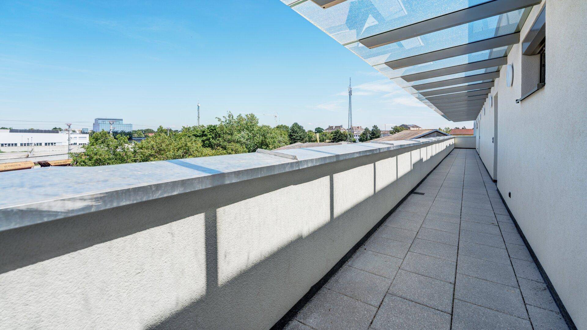Langer, schmaler Balkon mit Glasüberdachung und weitem Blick über die Umgebung.