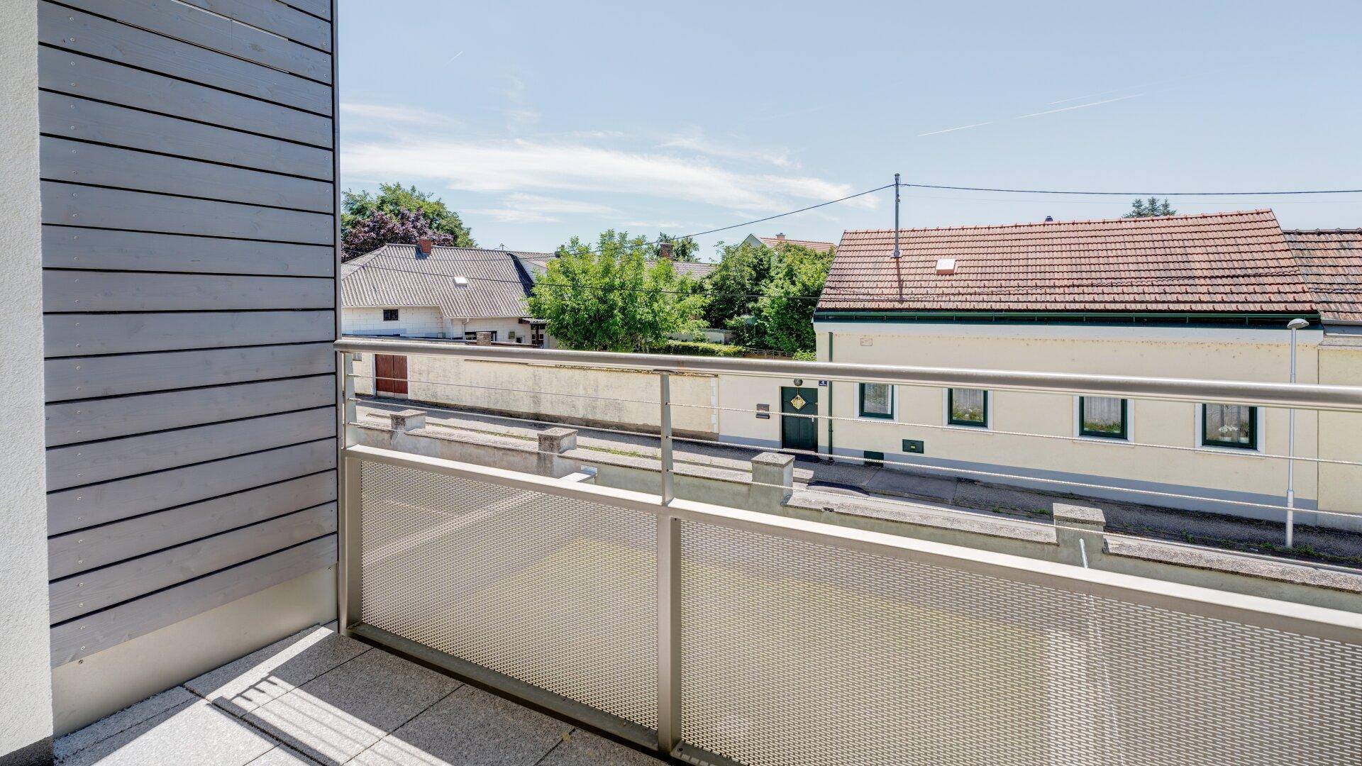 Moderner Balkon mit Metallgeländer und Blick auf die umliegende Wohngegend.