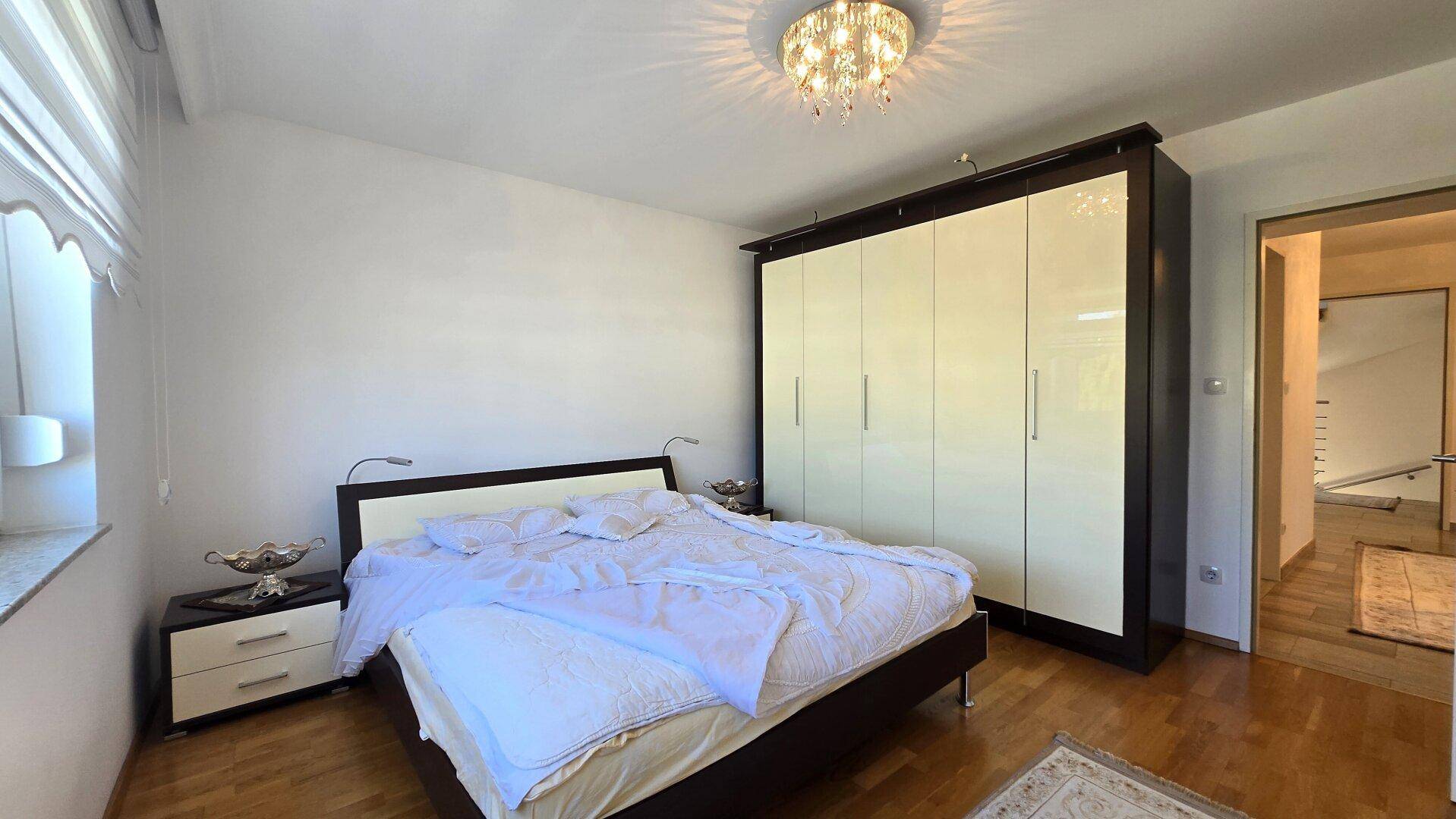 Gemütliches Schlafzimmer mit Doppelbett, Einbauschrank und Holzboden.
