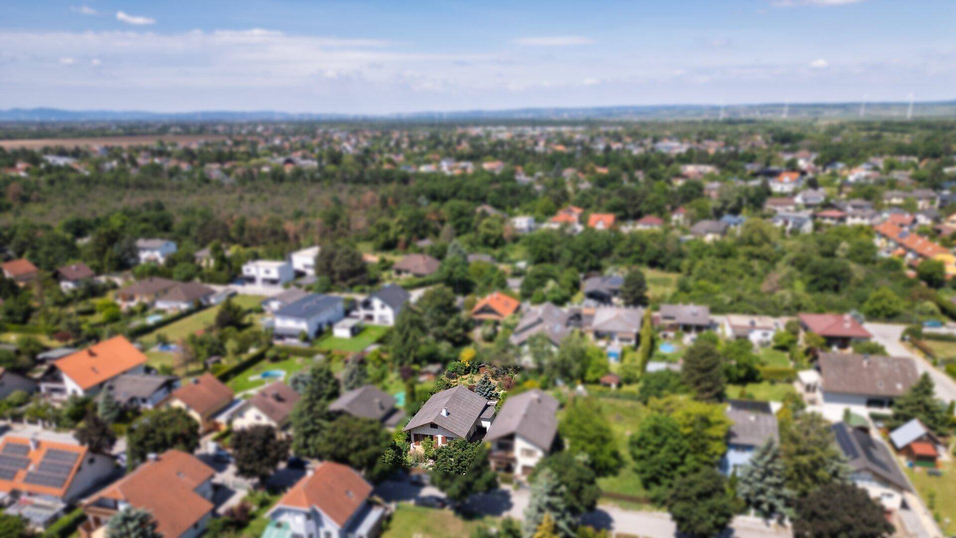 Weitläufige Luftaufnahme der Wohnsiedlung mit vielen Häusern und grünen Flächen.