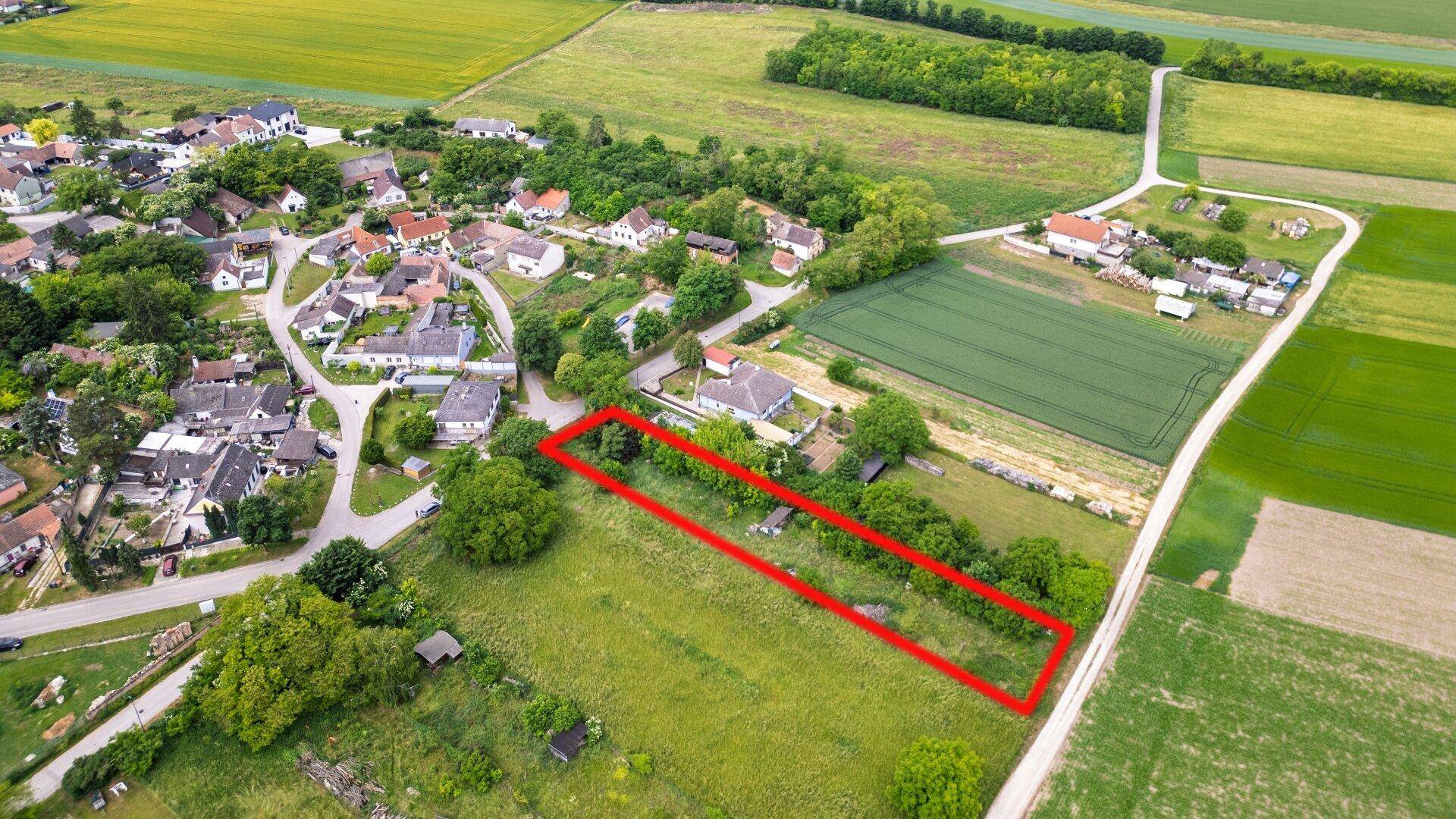 Panoramische Luftansicht des Grundstücks mit roter Markierung, umgeben von Feldern und Häusern.