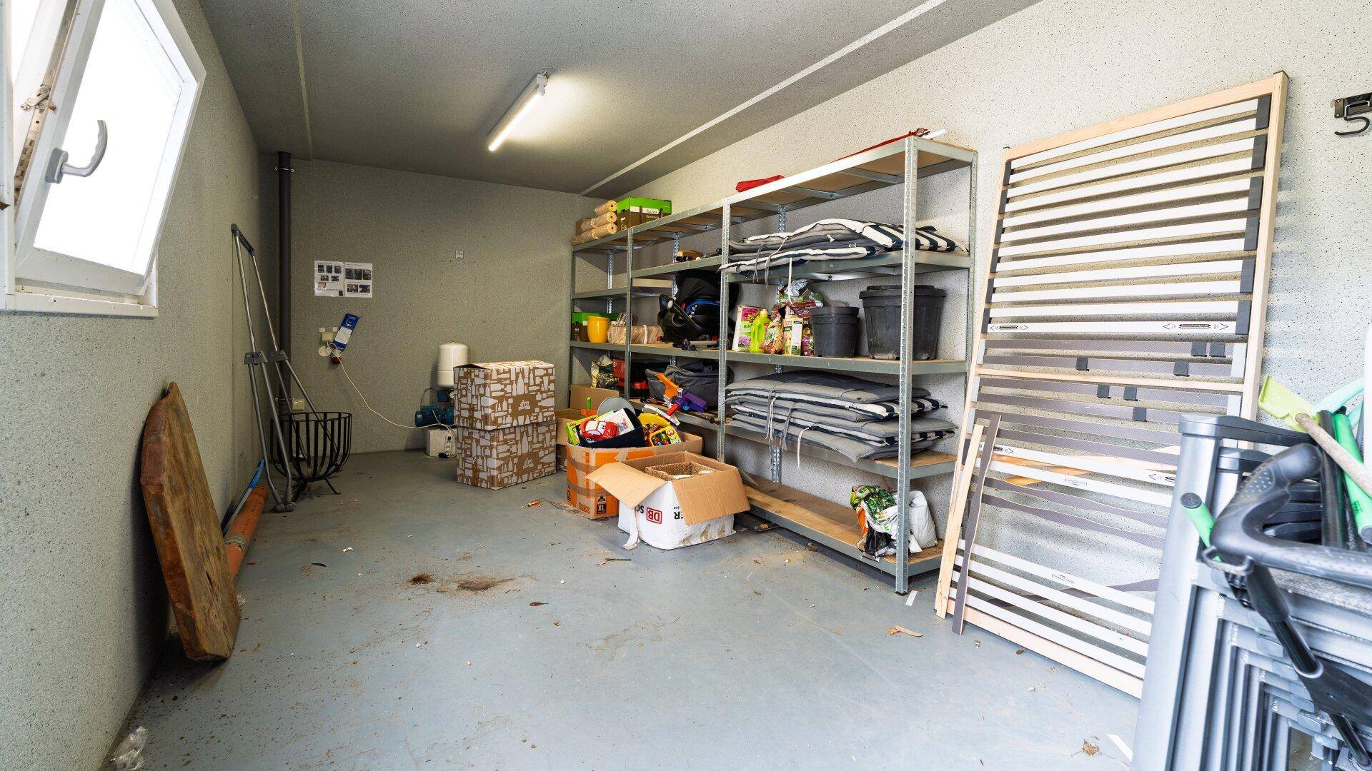 Geräumige Garage mit Regalen für Lagerung und einem Fenster.