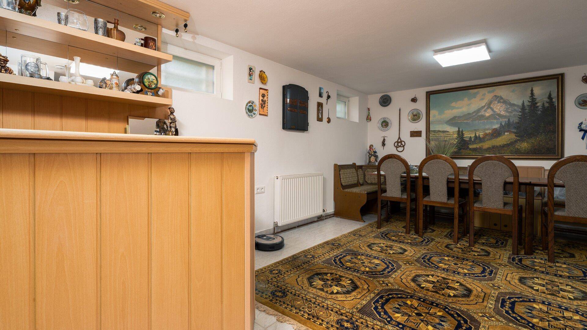 Gemütlicher Kellerraum mit Bar, Esstisch und traditioneller Dekoration an den Wänden.