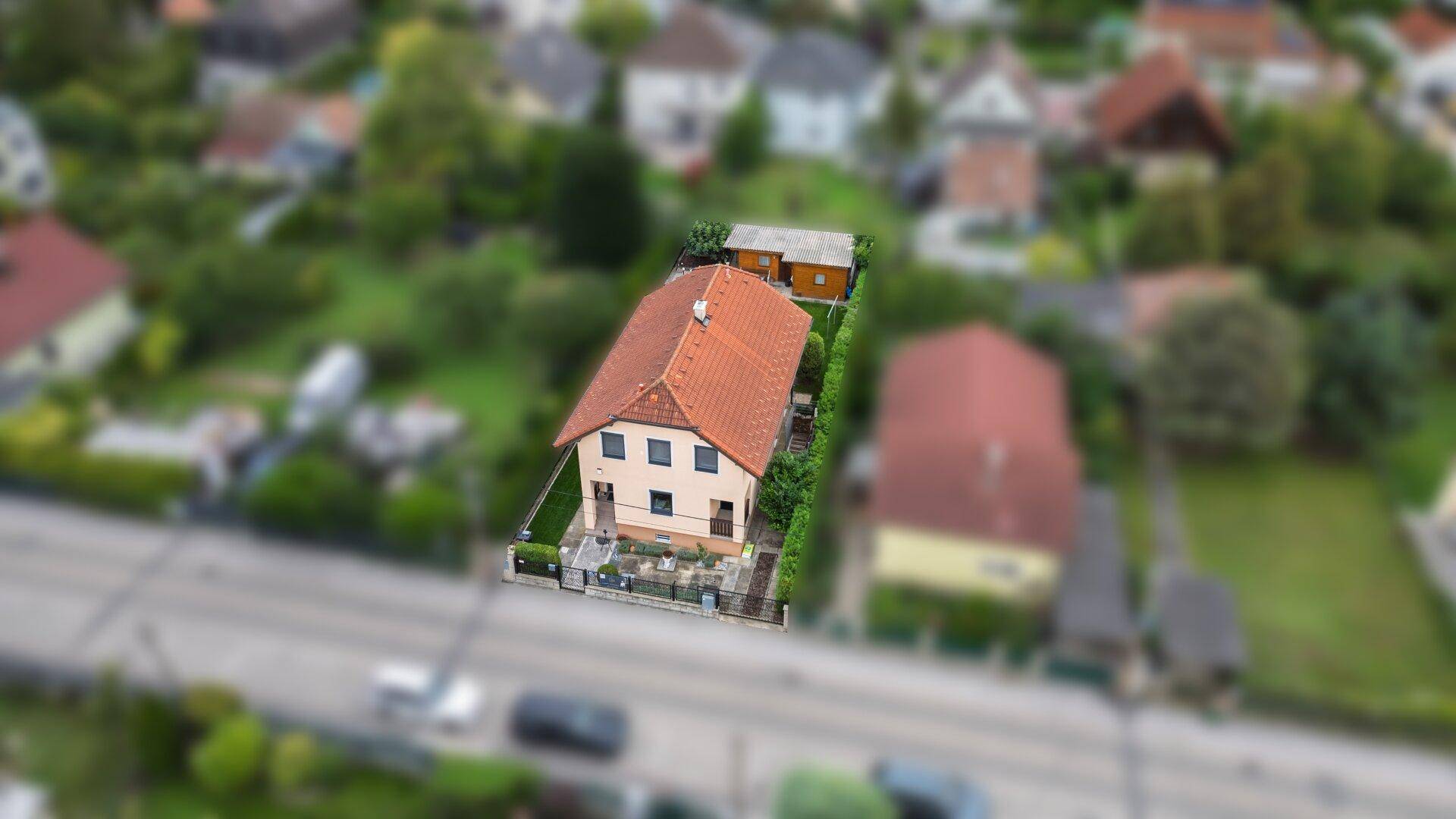 Schräge Luftaufnahme des Hauses mit Garten und der umliegenden Wohngegend.